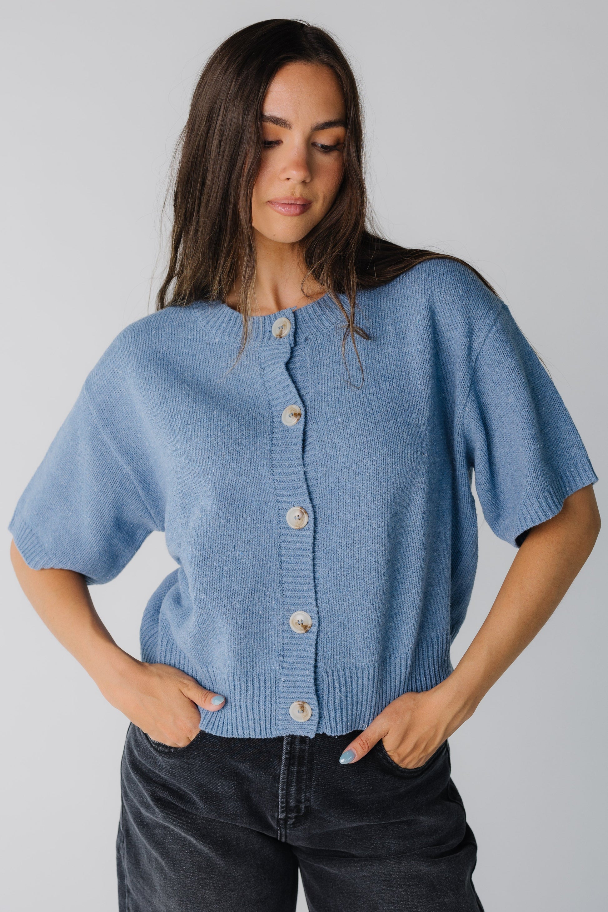 Blue loose fitting cardigan with large contrasting buttons and elbow length sleeve