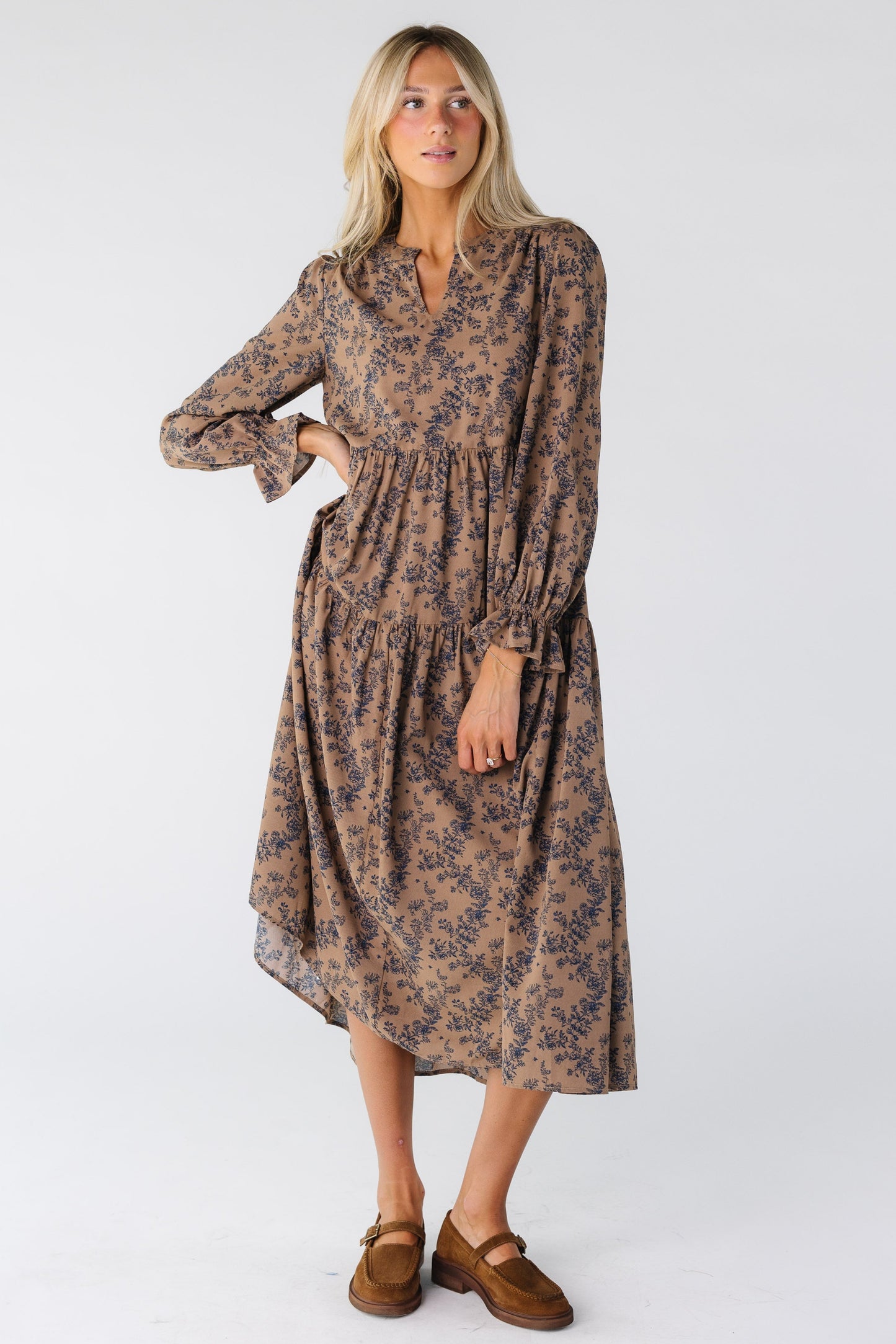 Woman wearing a brown tiered dress with navy floral print