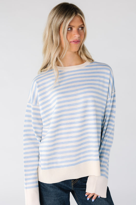 Woman wearing a light blue and white stripe loose fitting top