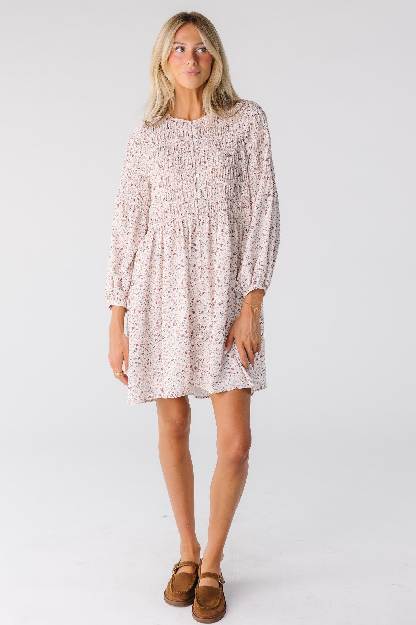 Woman wearing a long sleeve dress in cream floral print