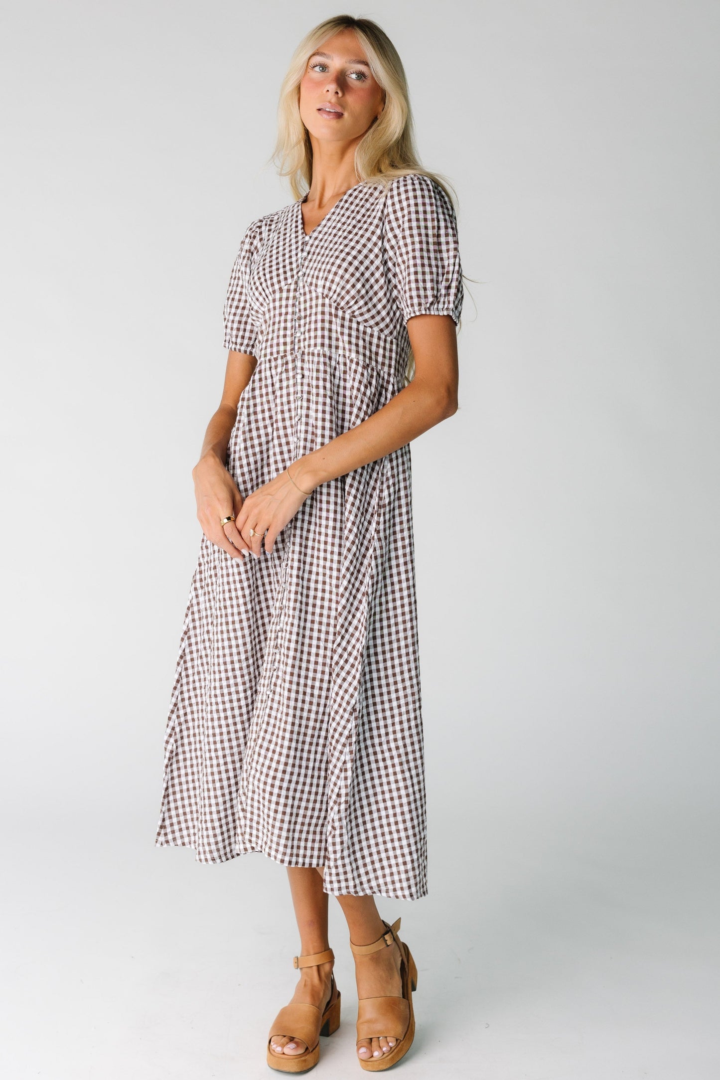 Woman wearing a brown and white gingham midi dress