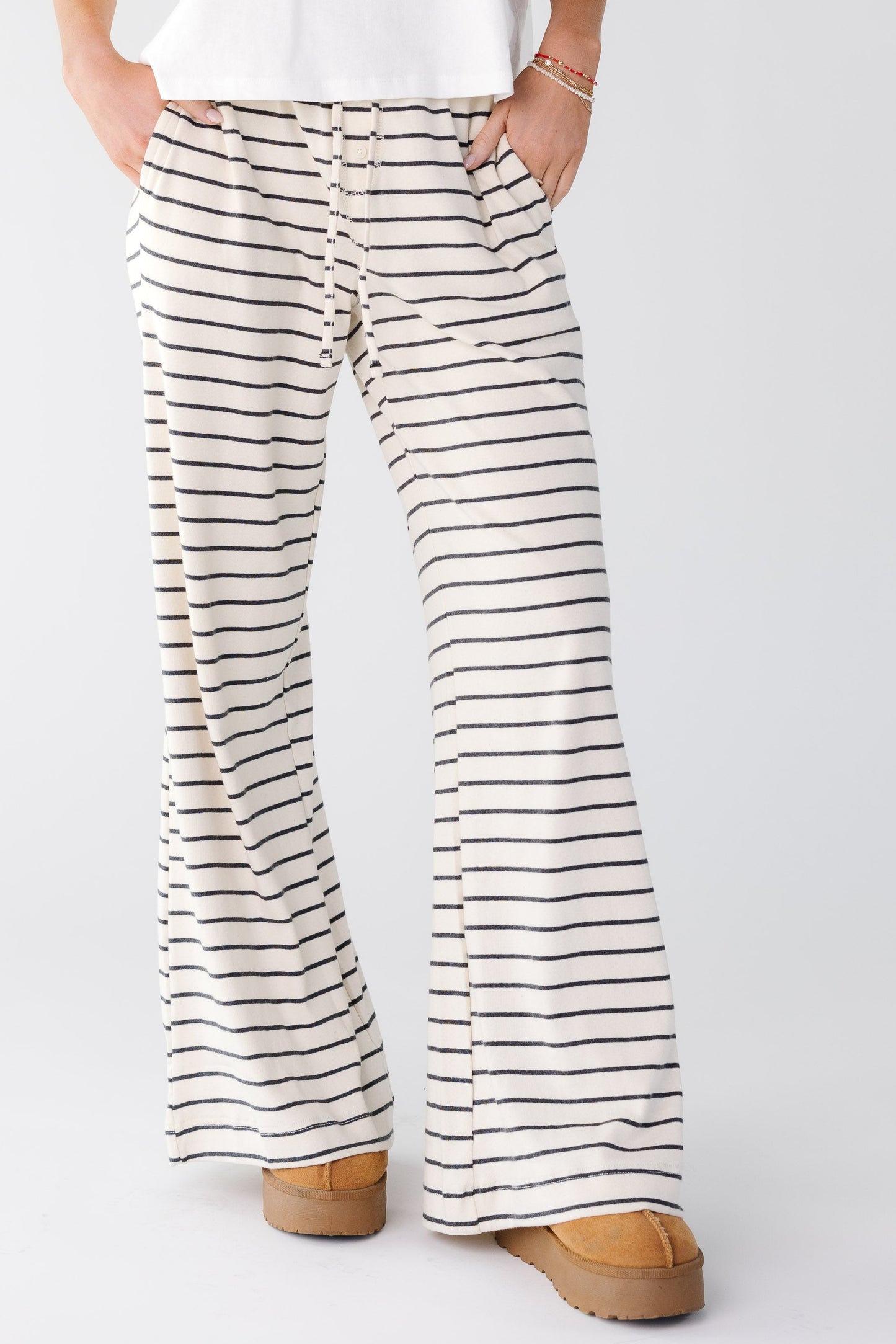 Woman wearing a full length wide length pant with pockets in white and black stripe