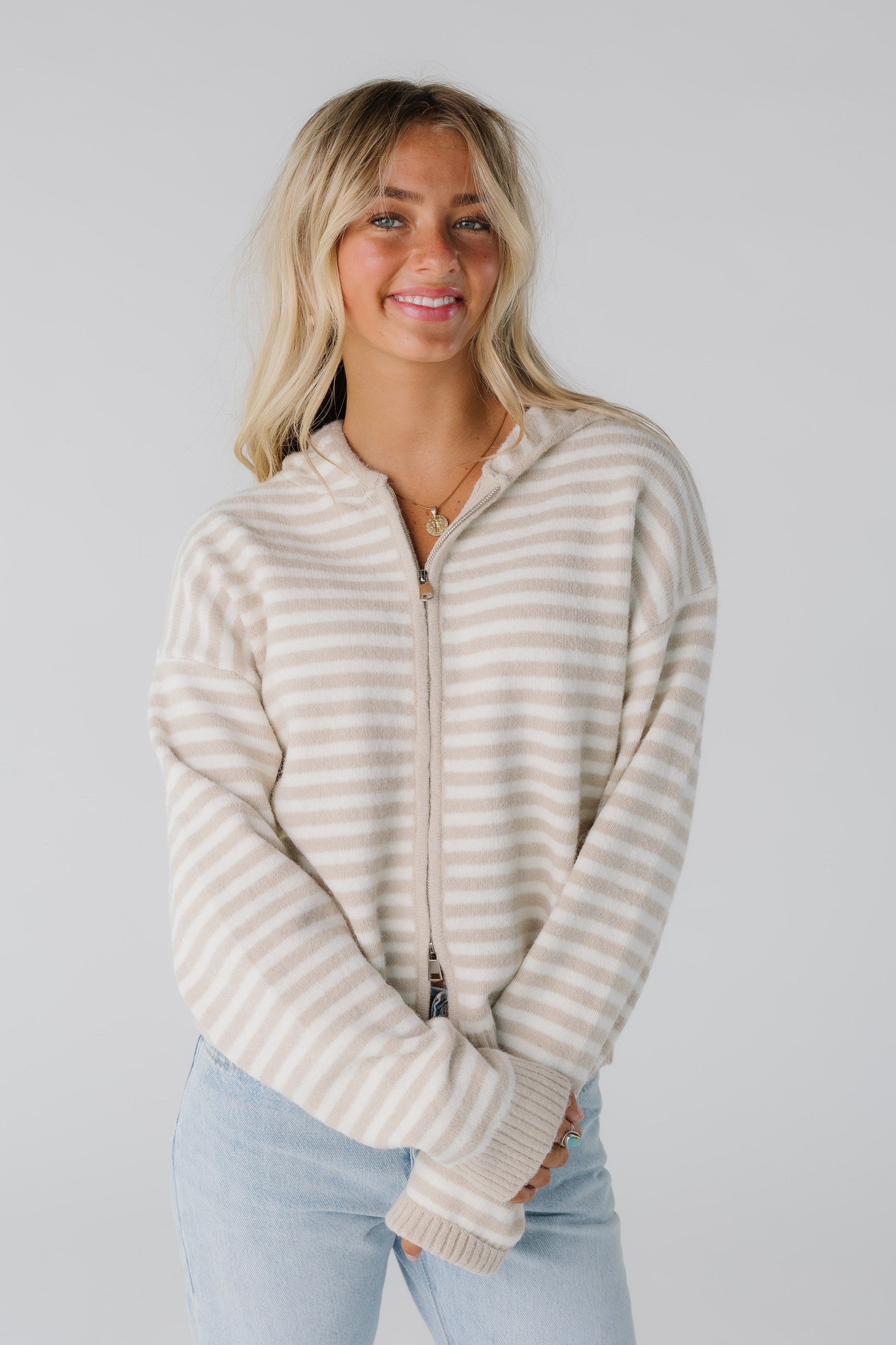 Woman wearing latte stripe cardigan with stripes and zipper