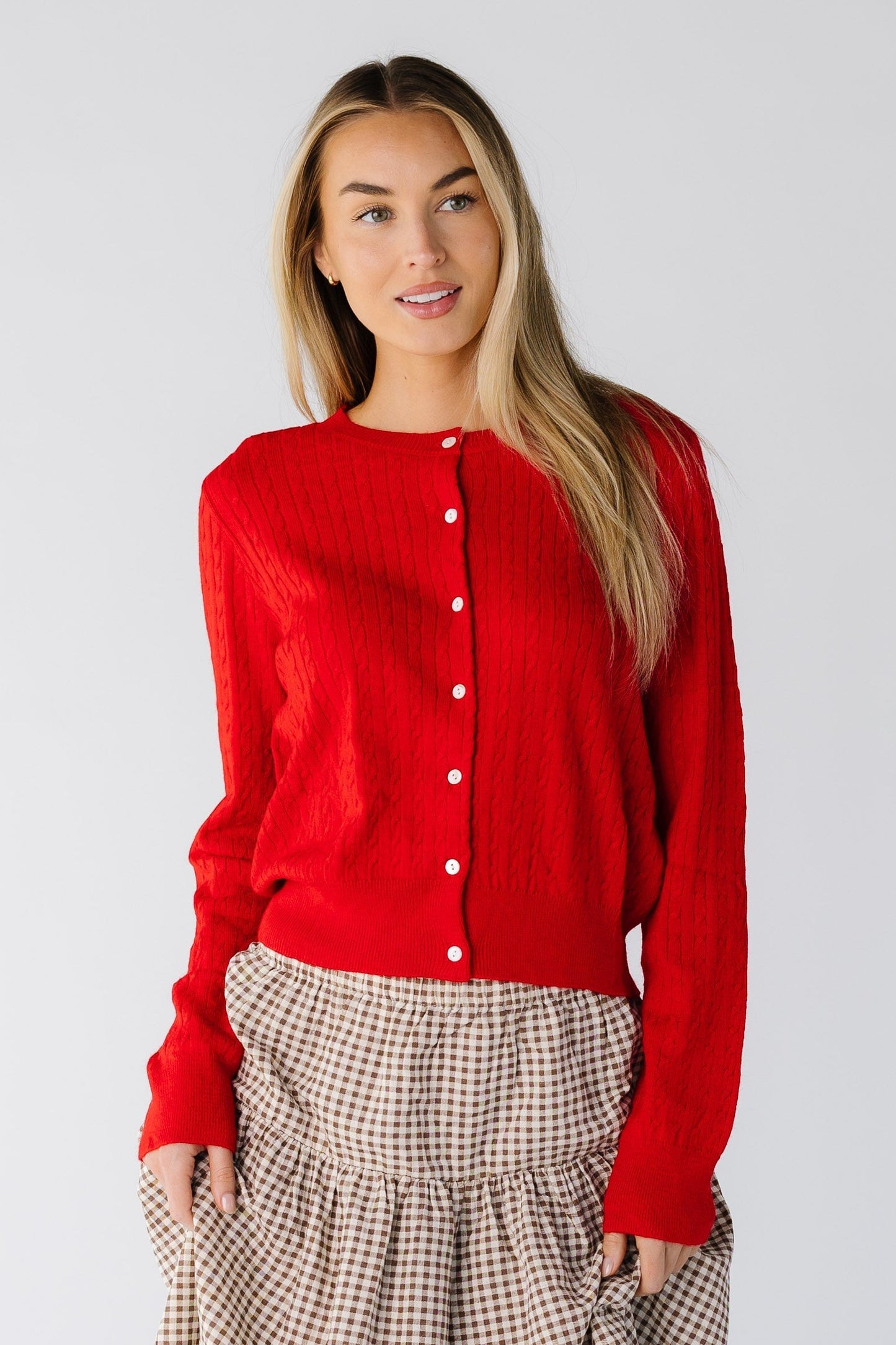 Woman wearing a long sleeve cardigan in red with a round neckline