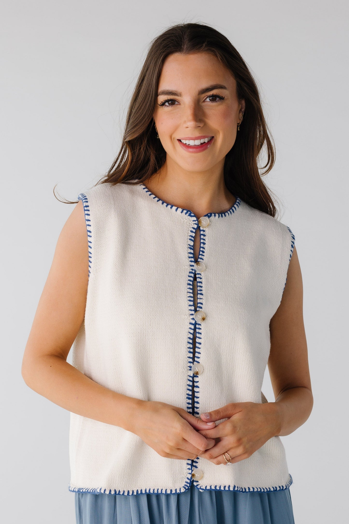 Sleeveless sweater vest with navy stitch detailing and buttons