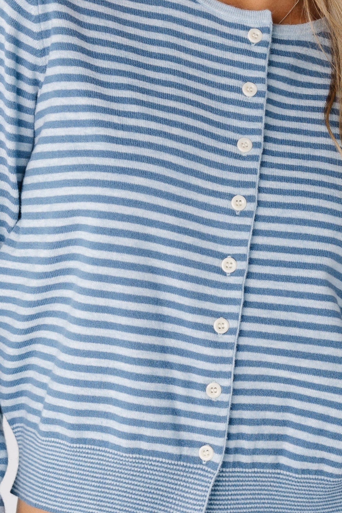 Woman wearing a blue stripe cardigan with round neckline and long sleeves