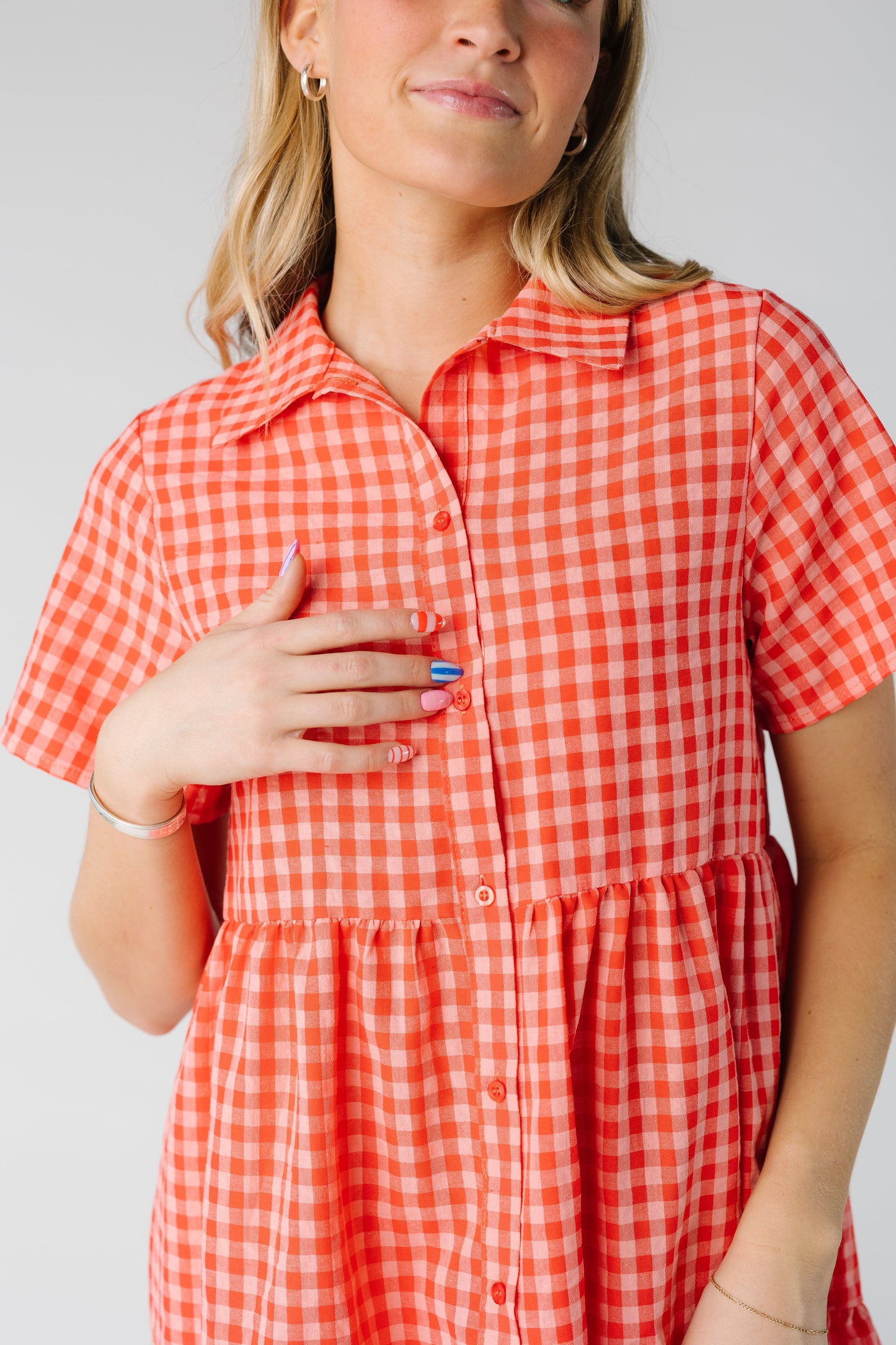 Close up of watermelon gingham dress with gathered waist