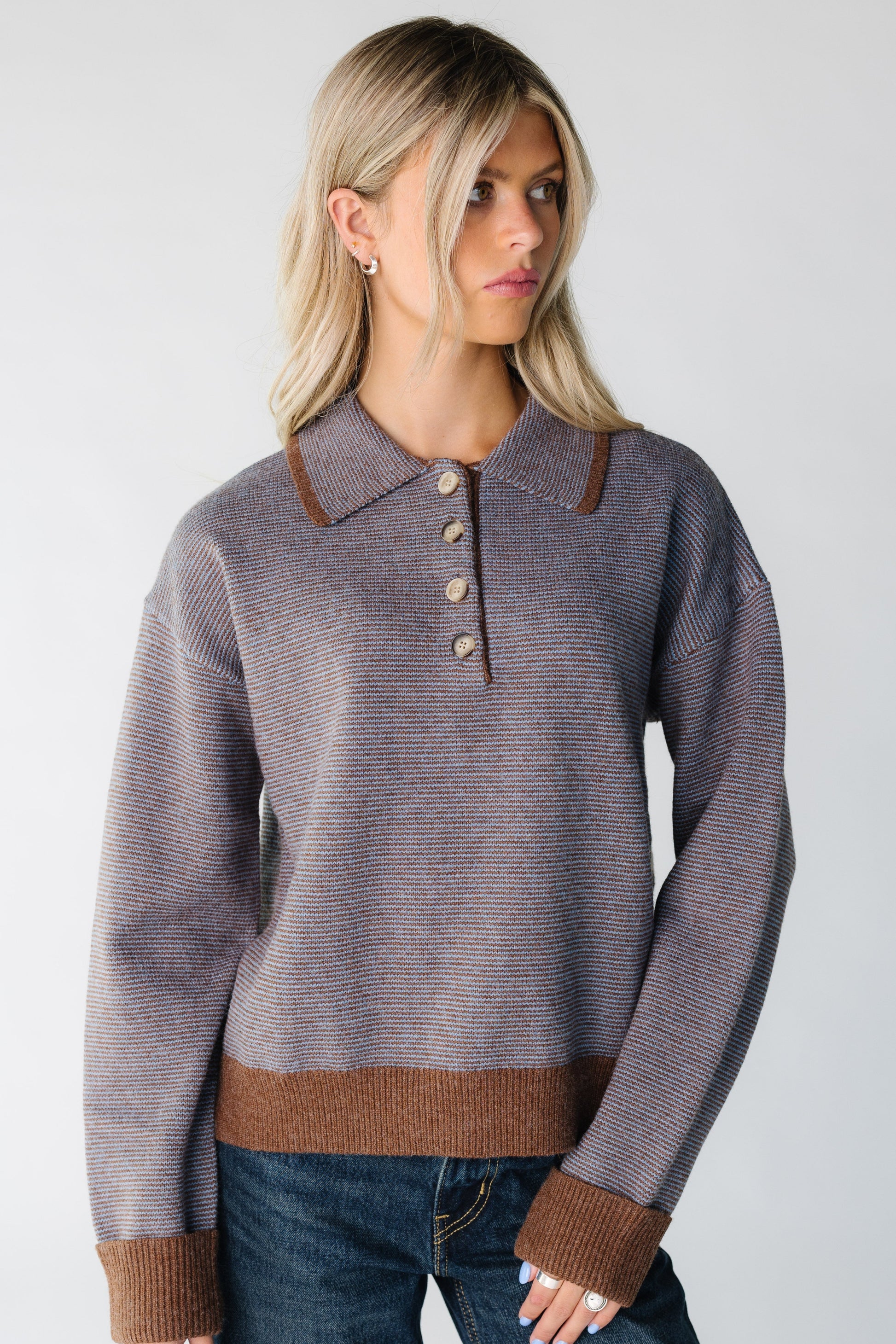 Woman wearing a brown stripe sweater with with wide rubbed cuffs and short button placket