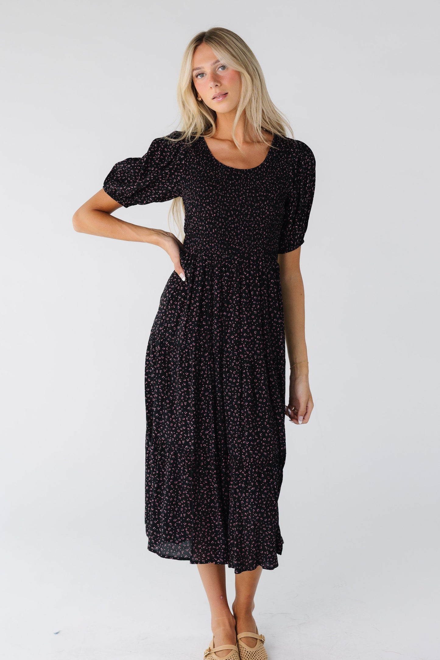 Woman wearing a black print midi with smocked bodice and full skirt