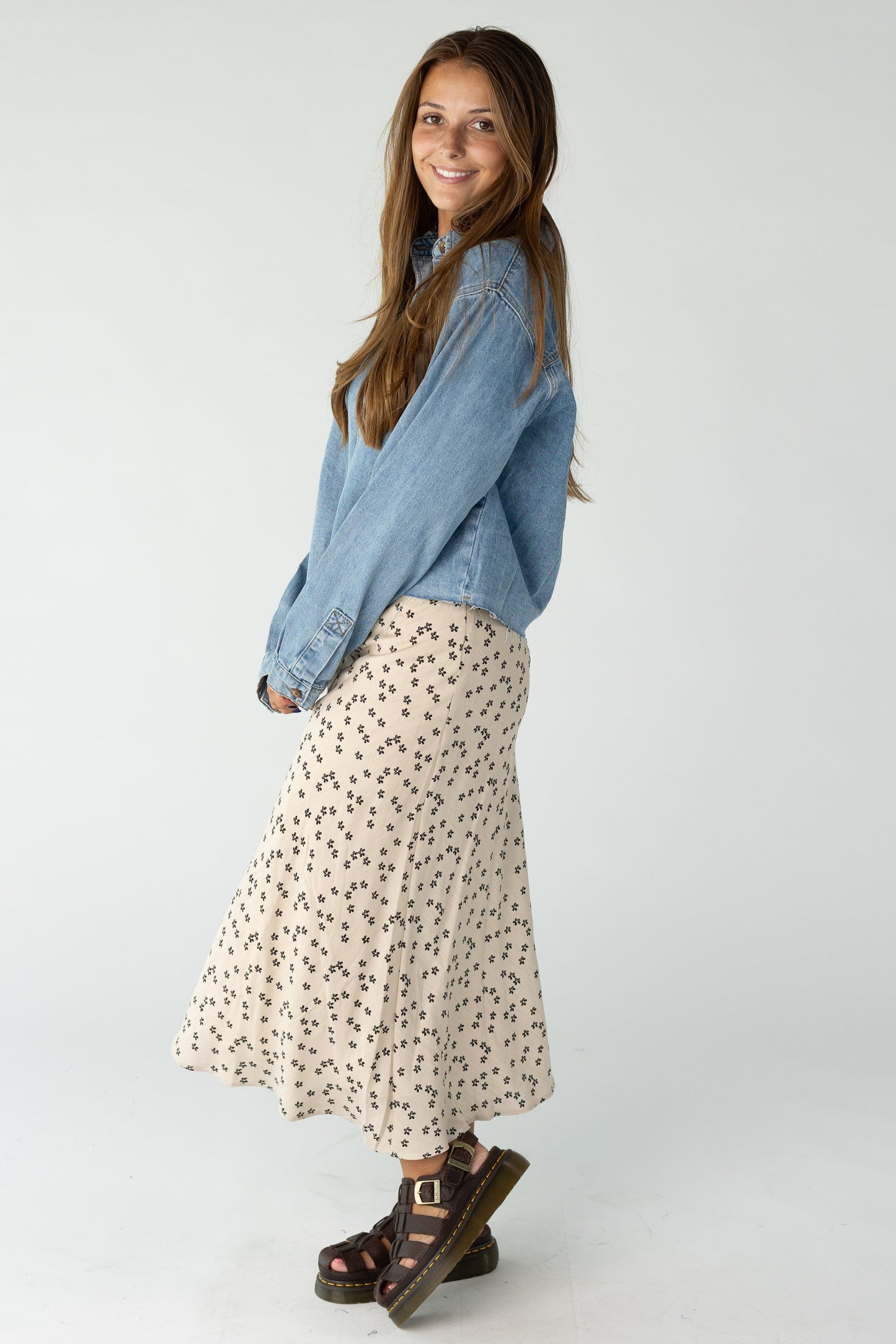 Woman wearing a tan midi skirt with black print