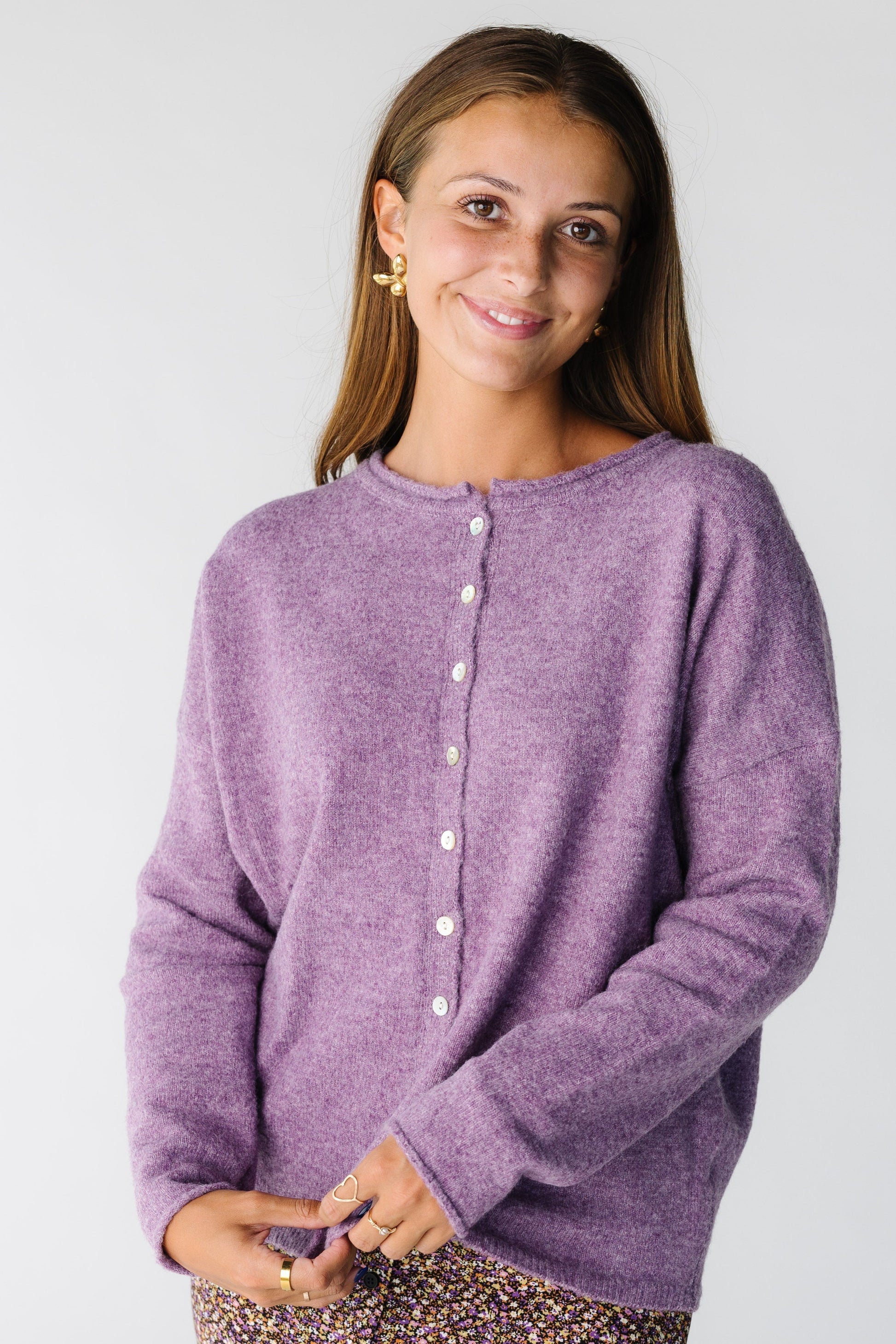 Woman wearing a button down cardigan with rolled hems in purple