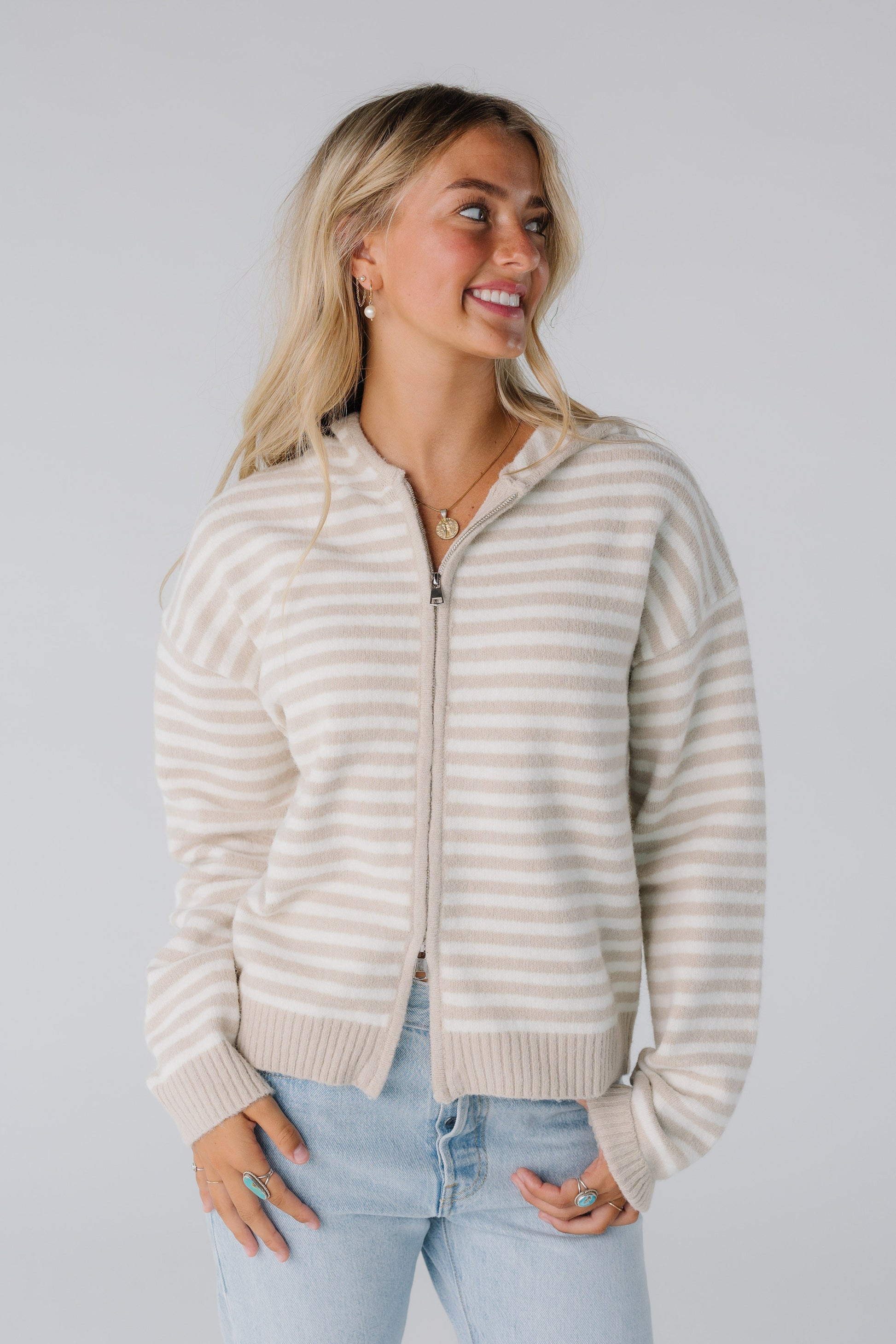 Woman wearing striped zipper cardigan in latte and ivory