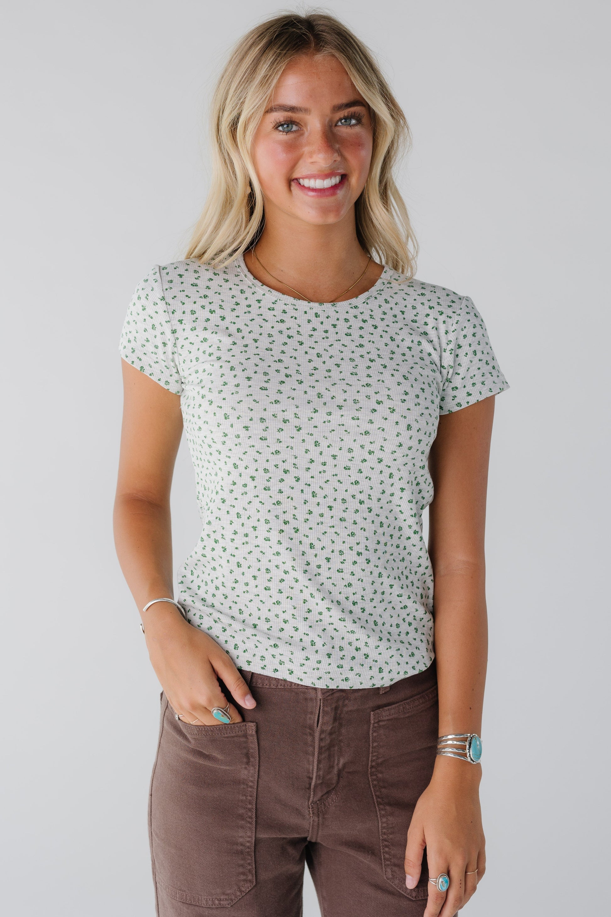 Woman wearing grey floral top with short sleeves