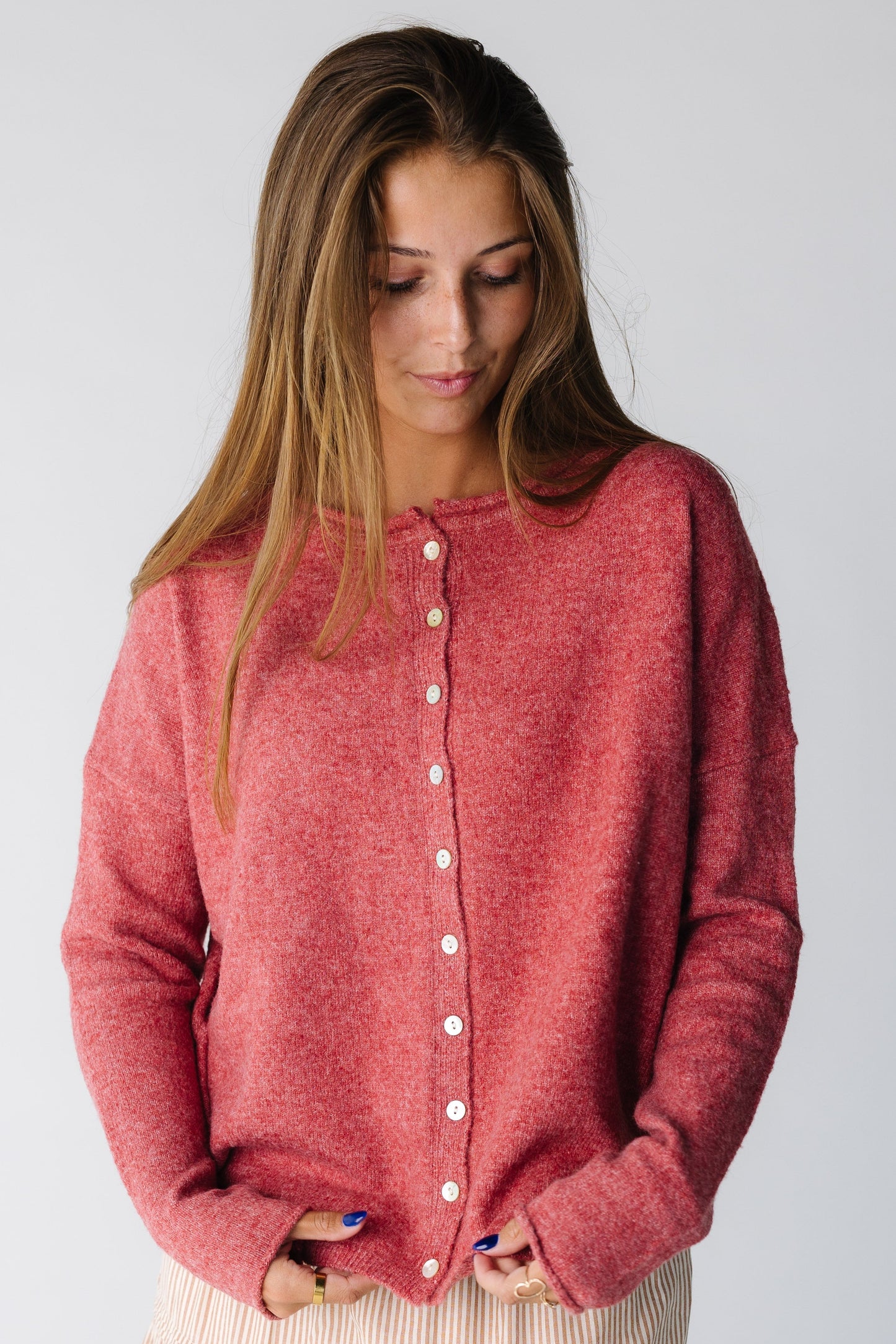 Woman wearing a  heather berry button down cardigan