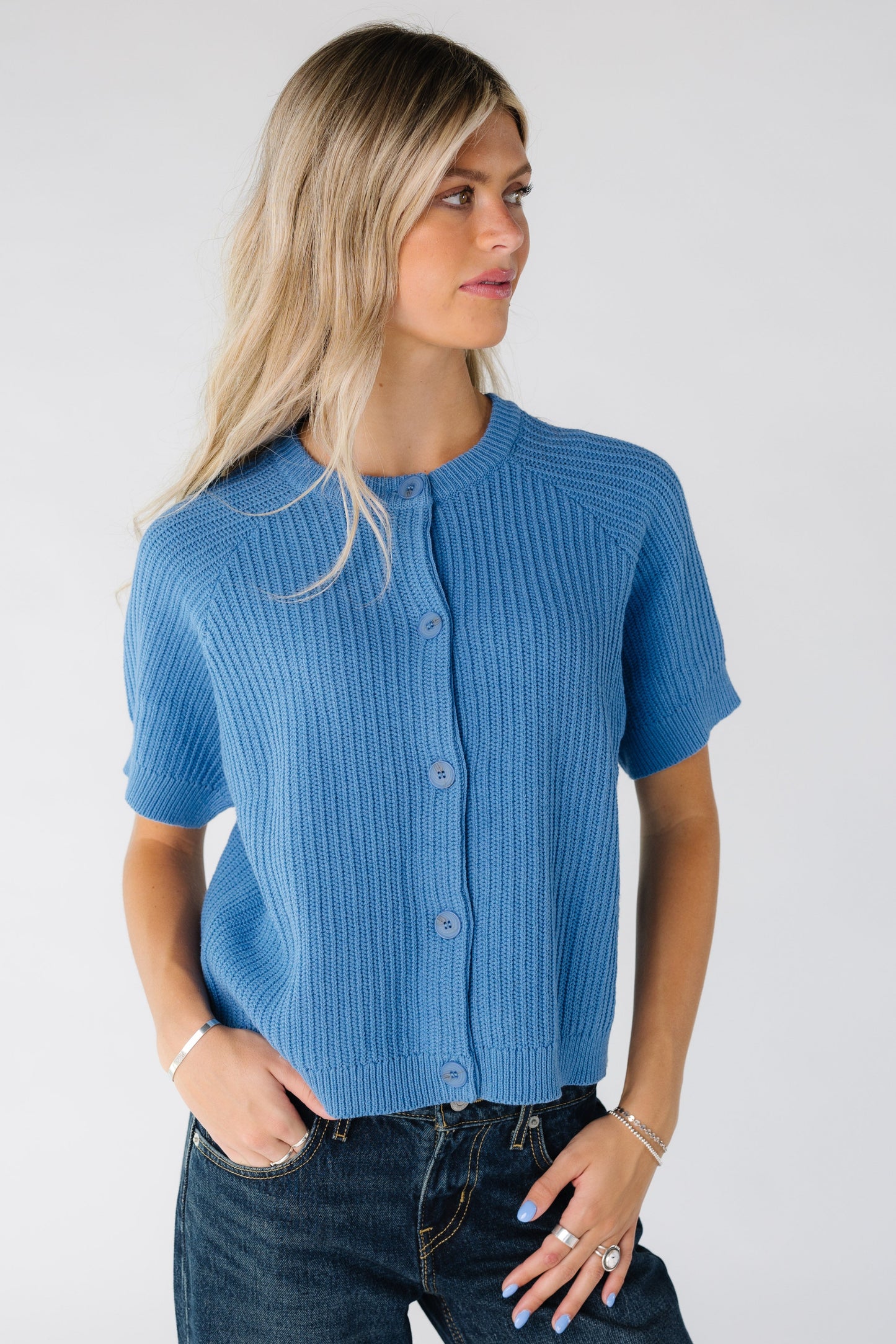 Woman waring a blue textured stripe cardigan with short sleeves