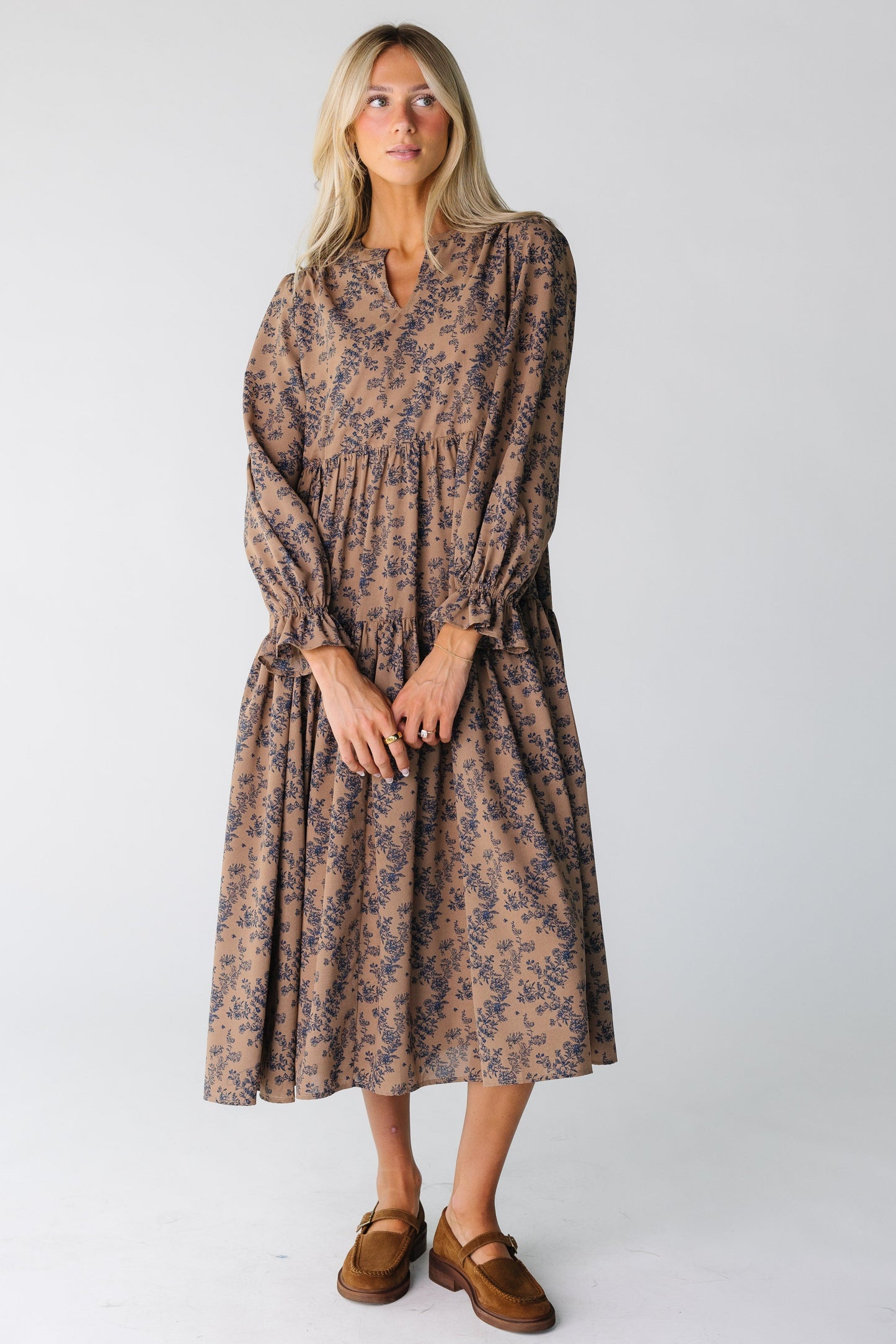 Woman wearing brown floral print midi dress with long sleeves