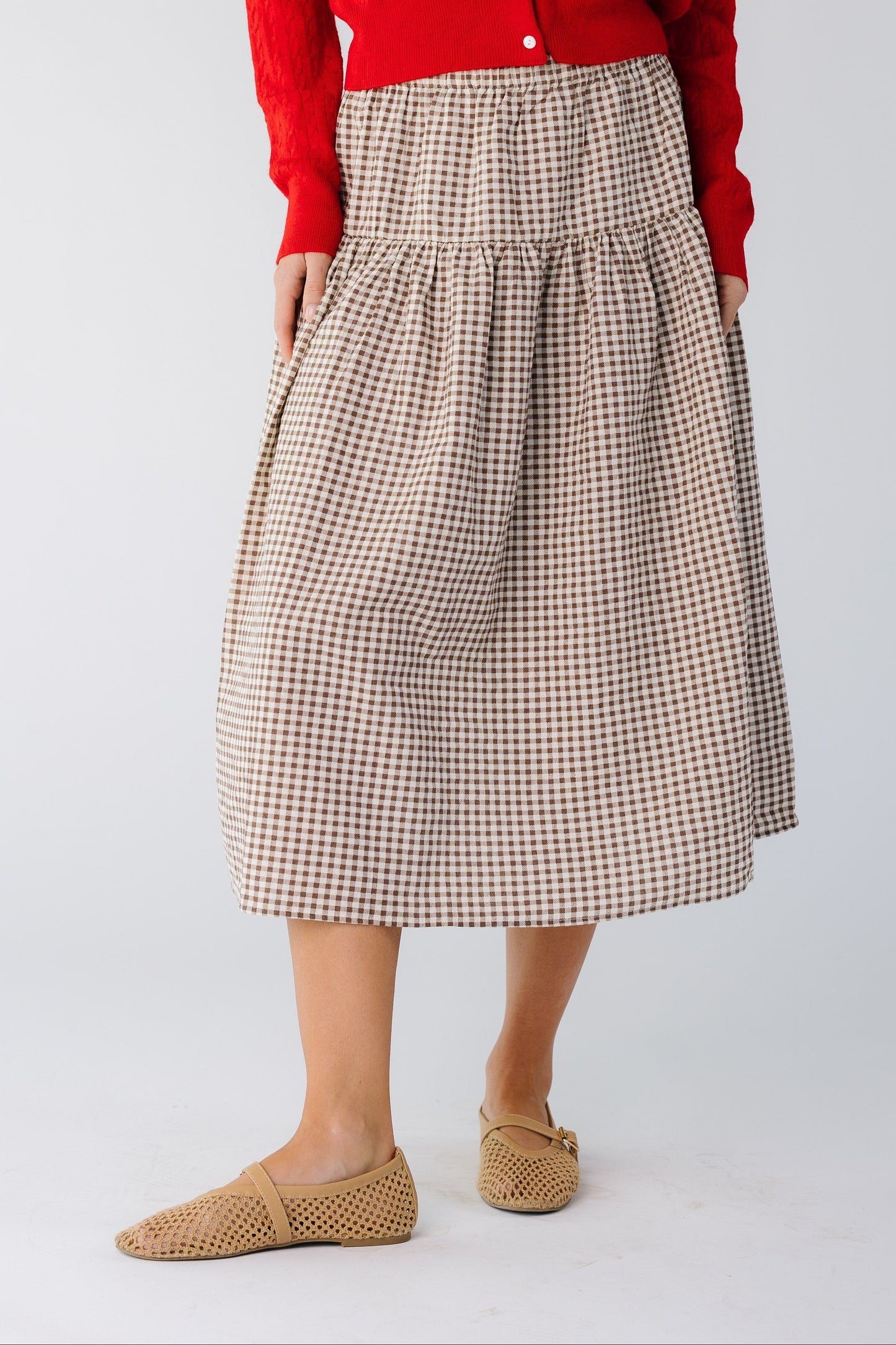 Woman wearing a drop waist midi skirt in brown gingham