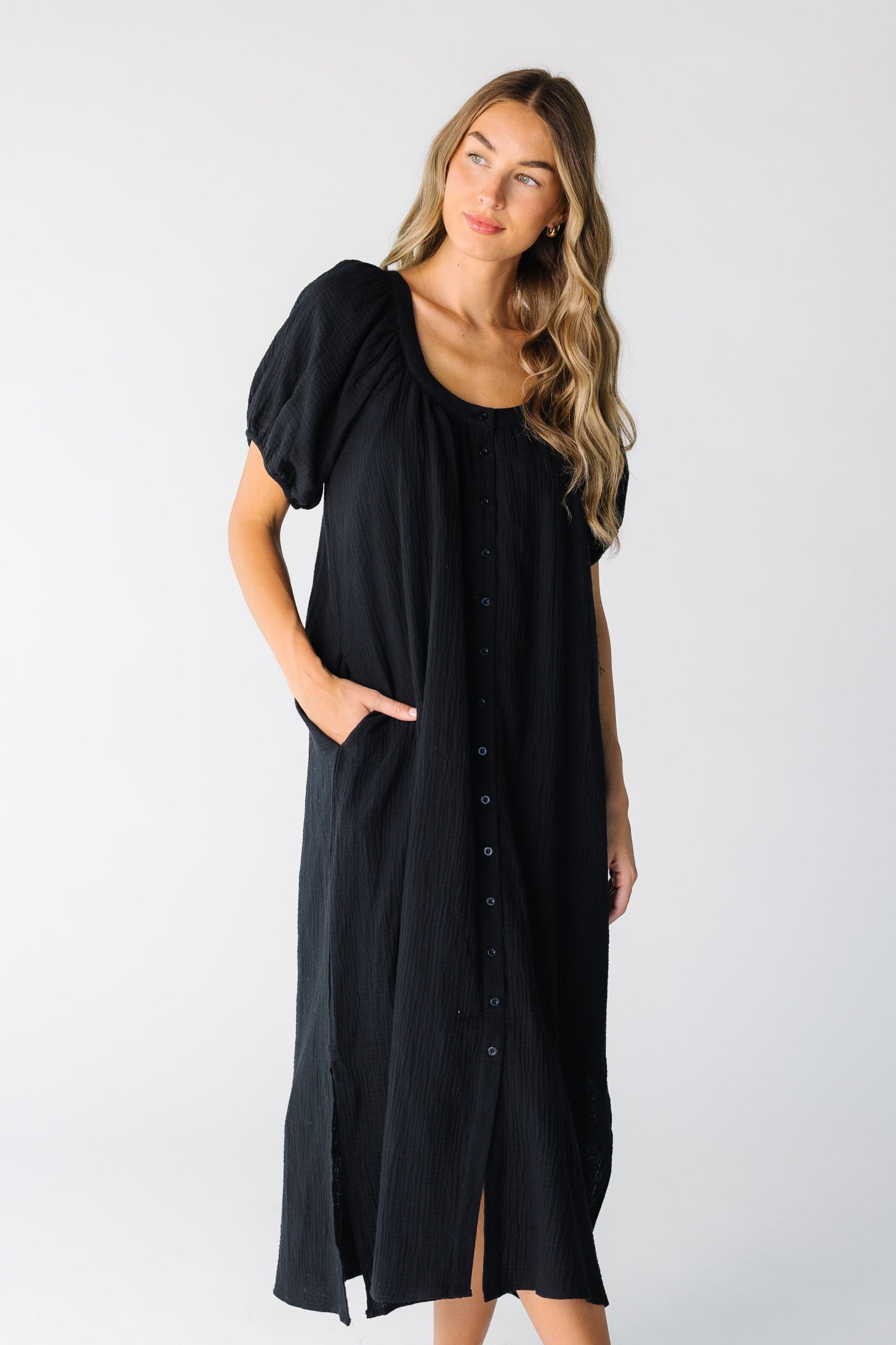 Woman wearing a black gauzy button down midi dress