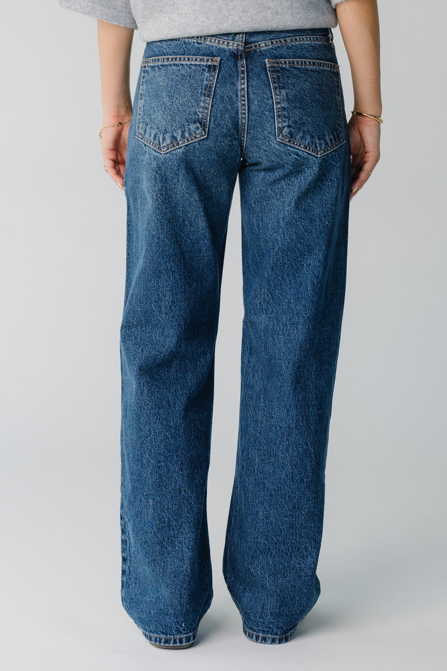 Back view of women's dark denim straight leg jeans
