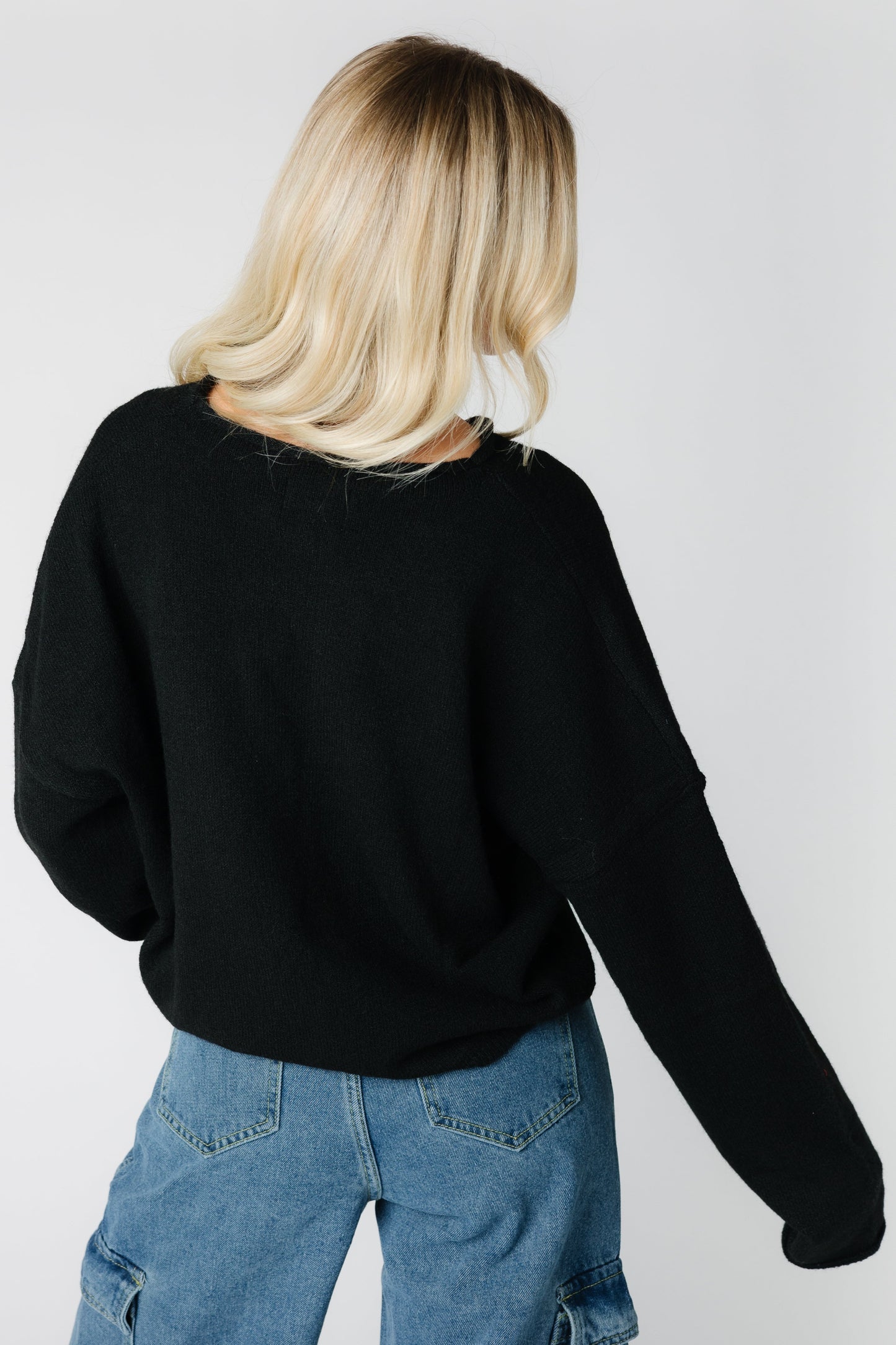 Back view of a woman wearing a black long sleeve cardigan