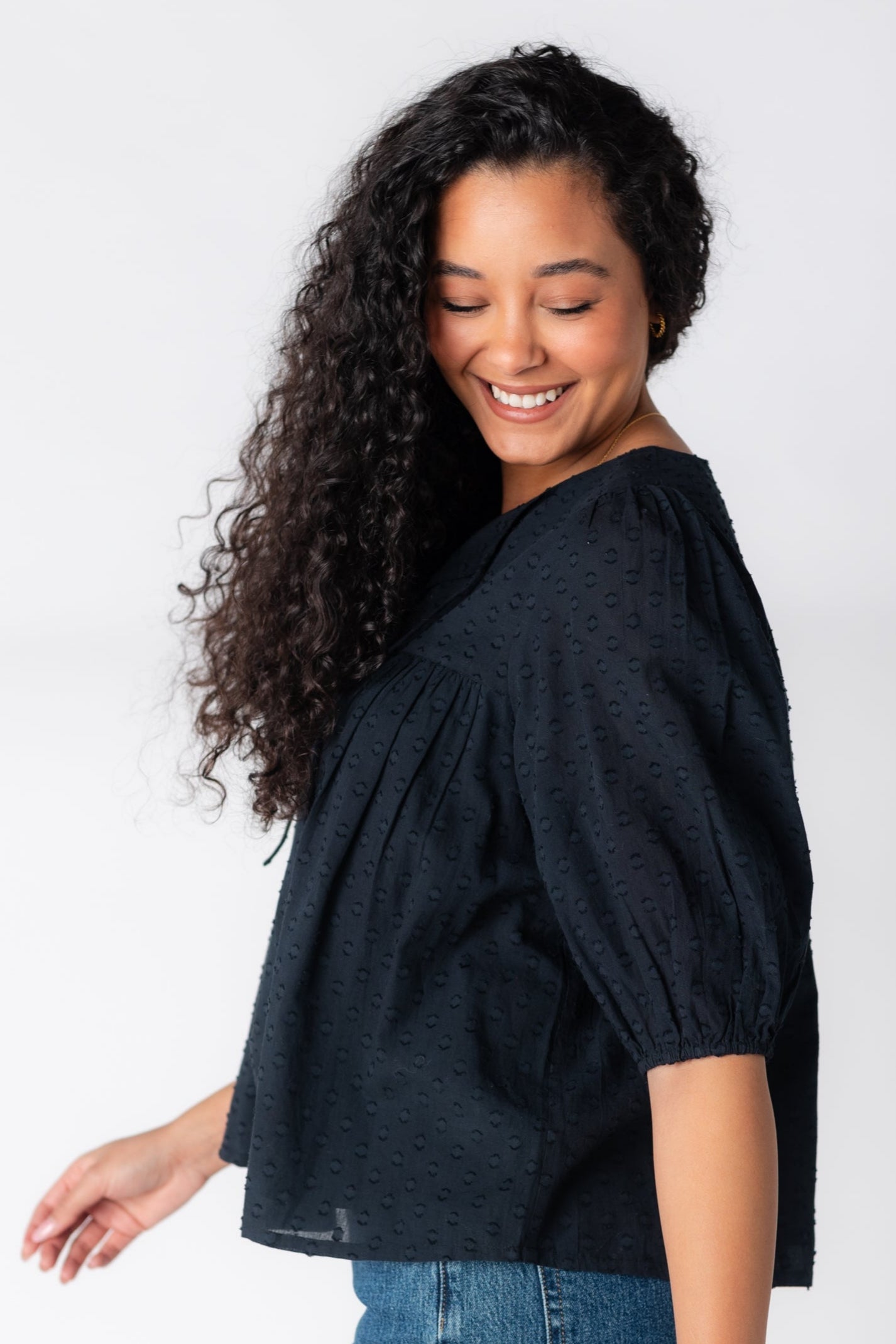 Side view of black textured blouse with half length sleeves