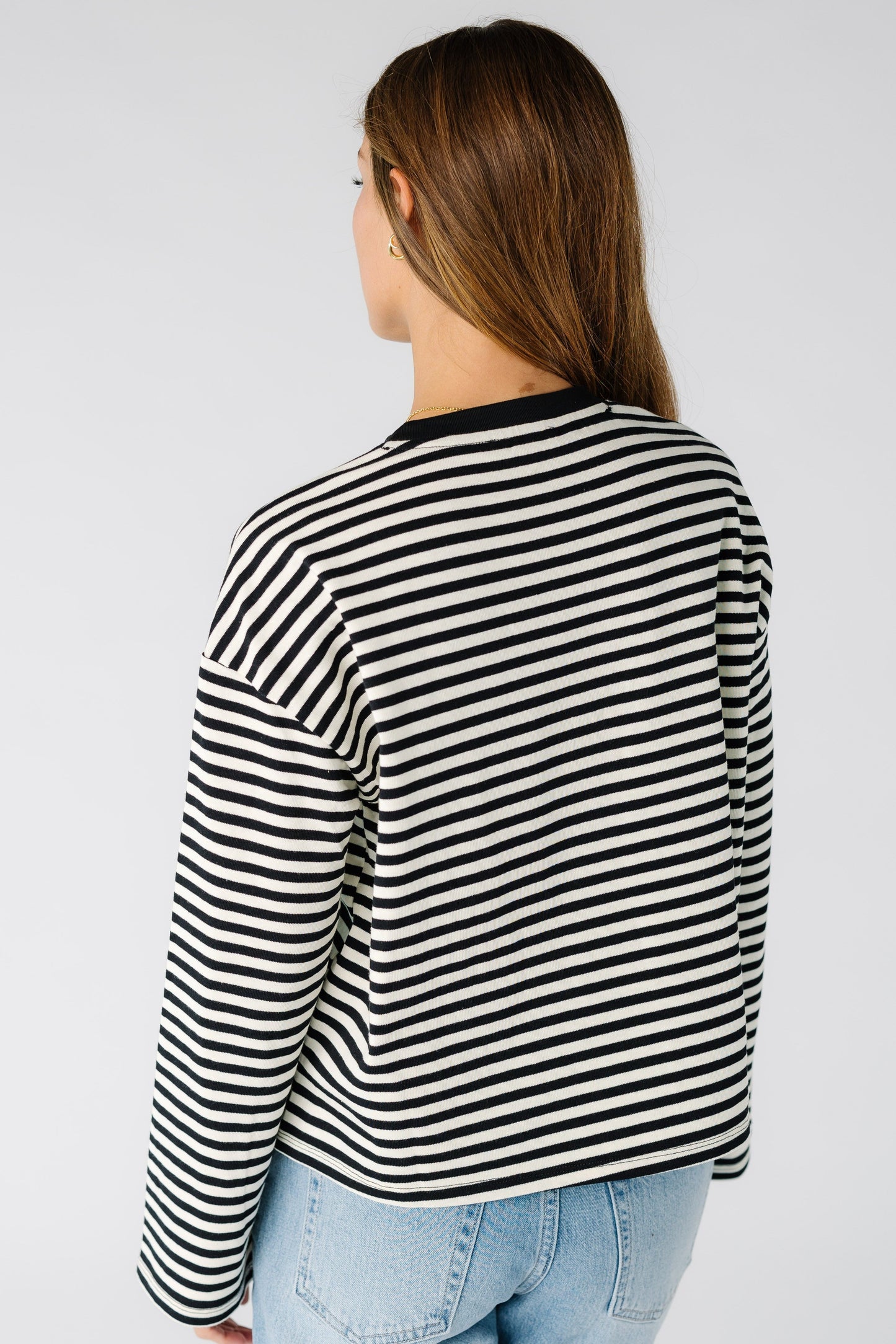 Back view of a woman wearing a black and white stripe tee with long sleeves