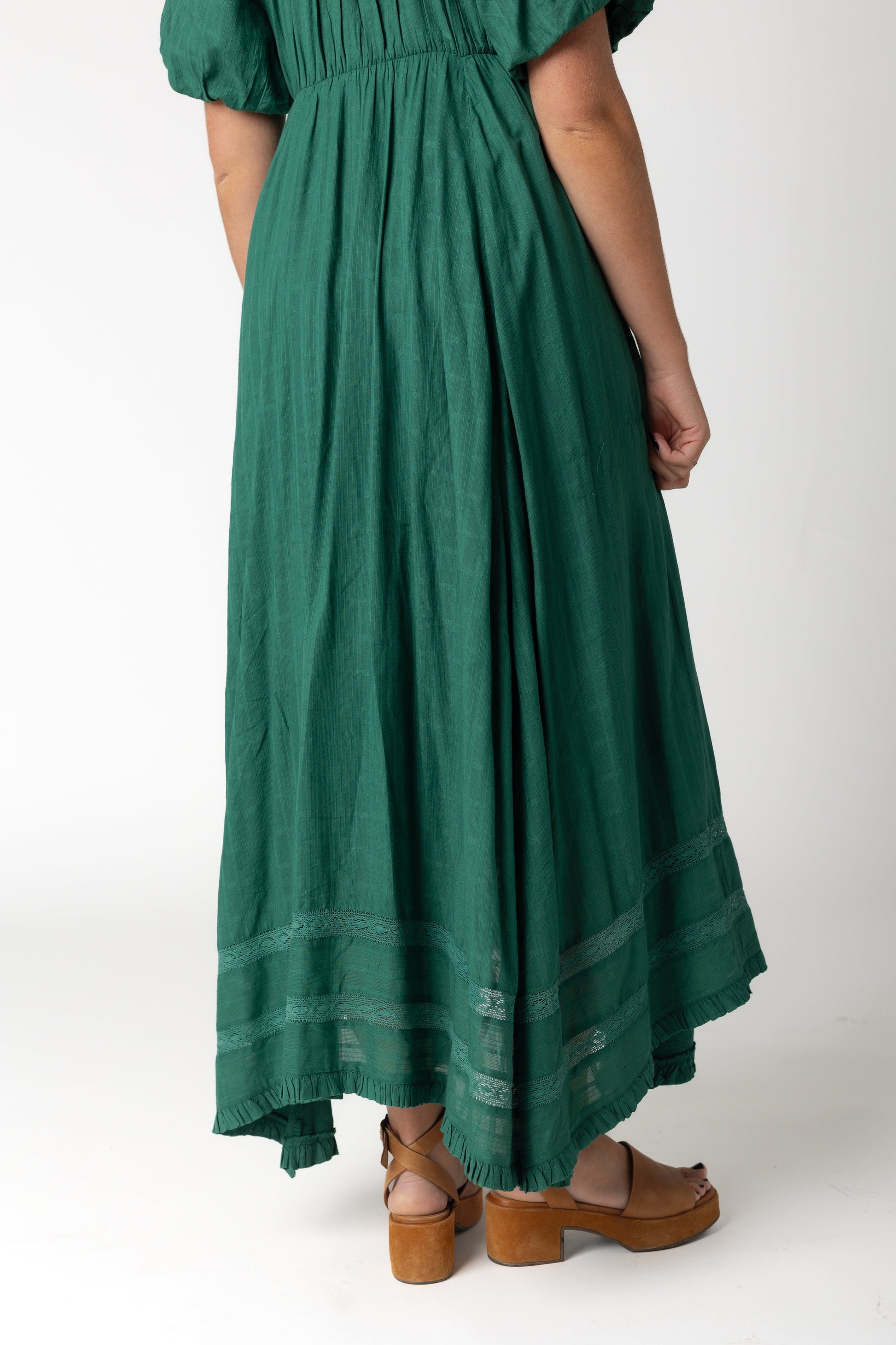 Close view of a woman wearing a green dress with lace insets
