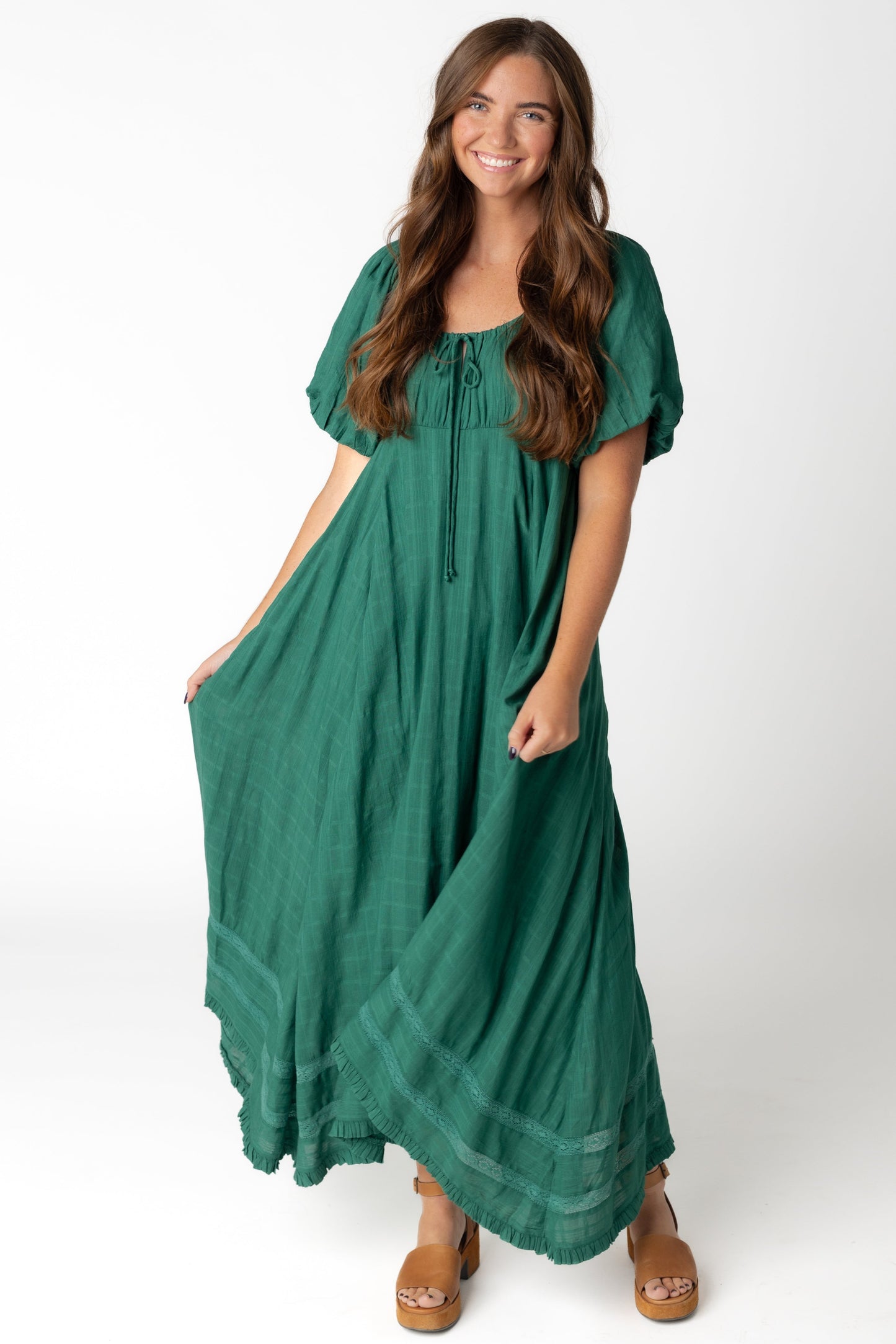 Woman wearing a green full midi dress with scoop neckline and short sleeves
