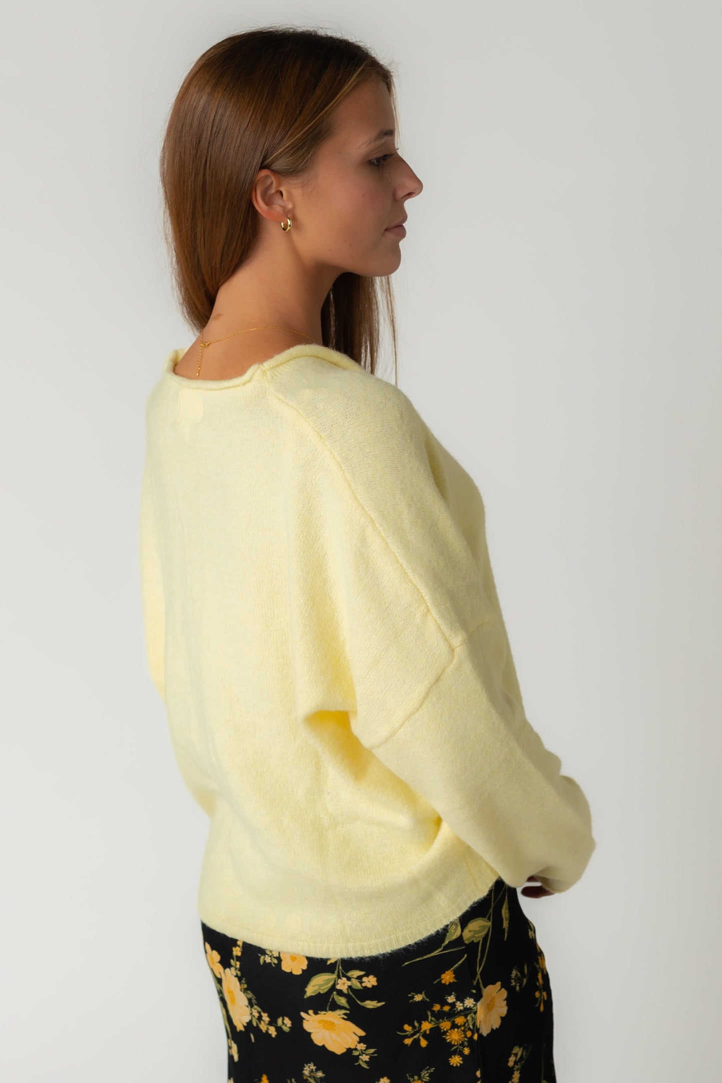 A back view of a woman wearing a light yellow cardigan
