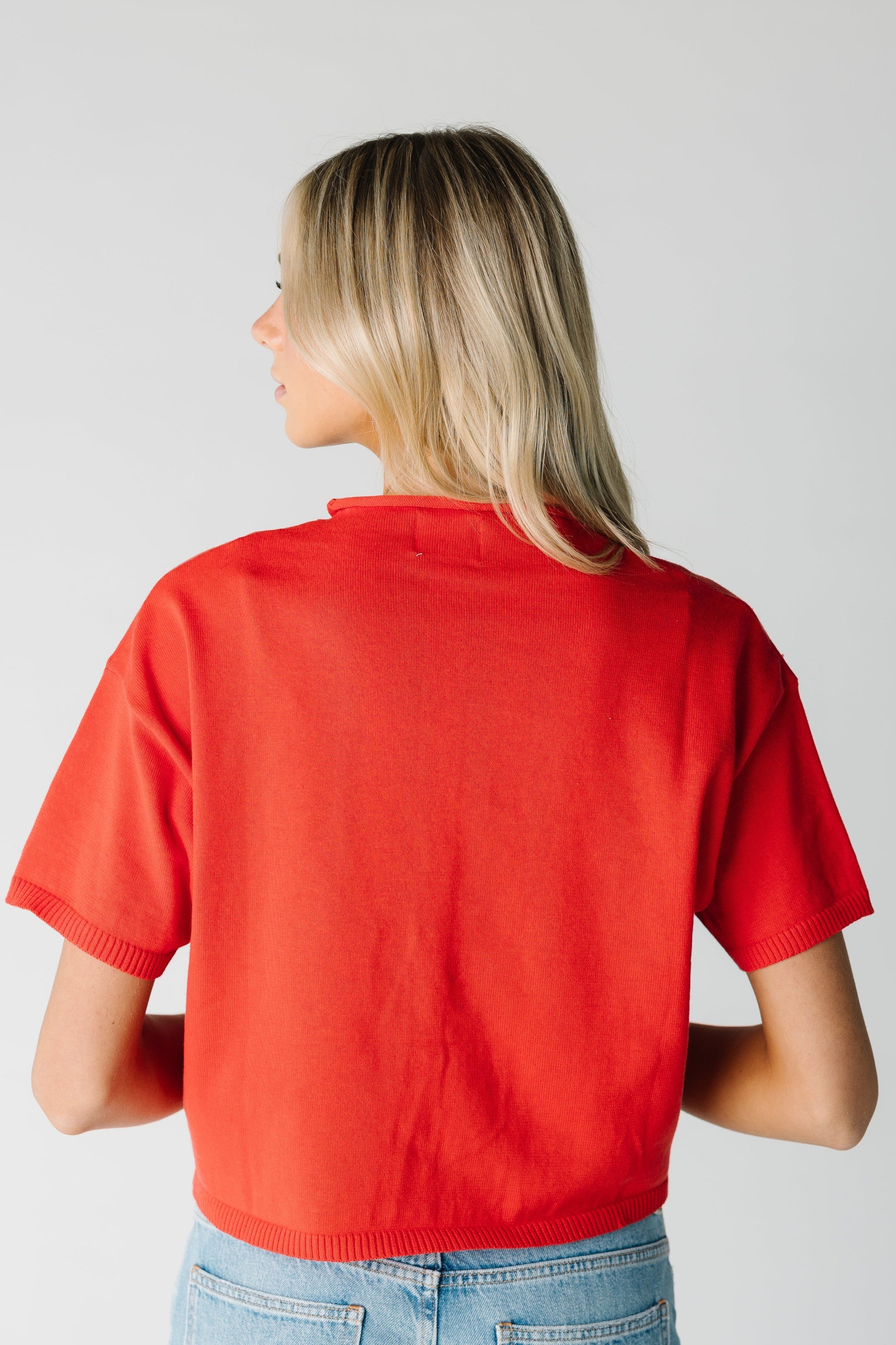 Back view of women's red knit top with short sleeves