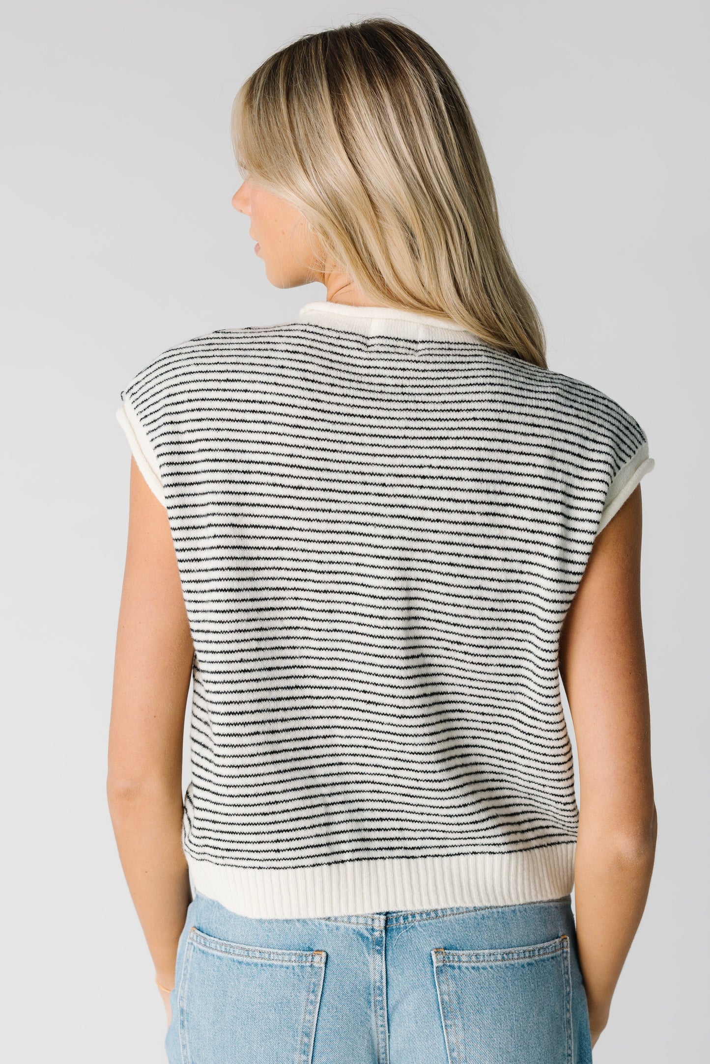 Back view of black and white sweater vest