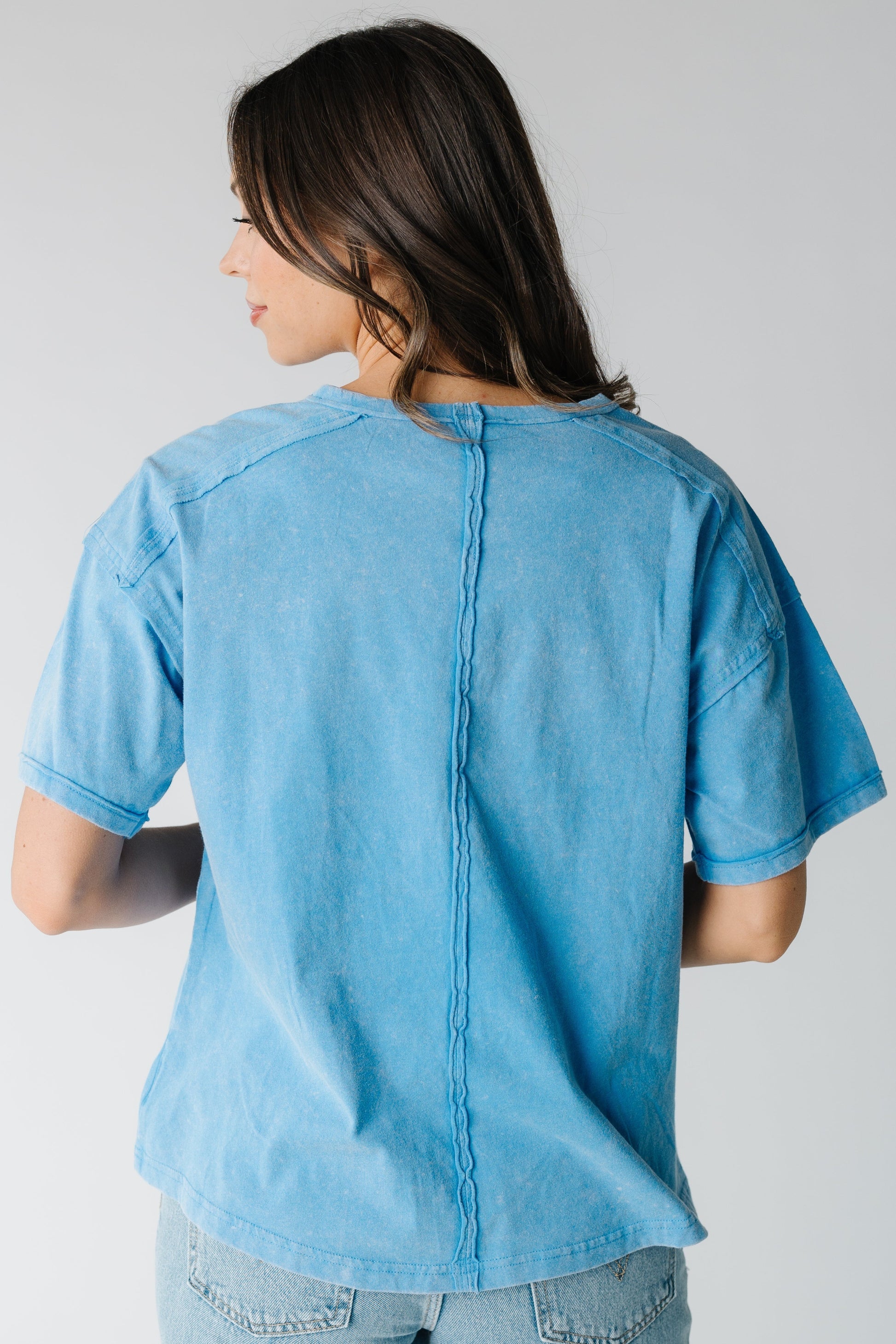 Back view of blue tee with seam style details