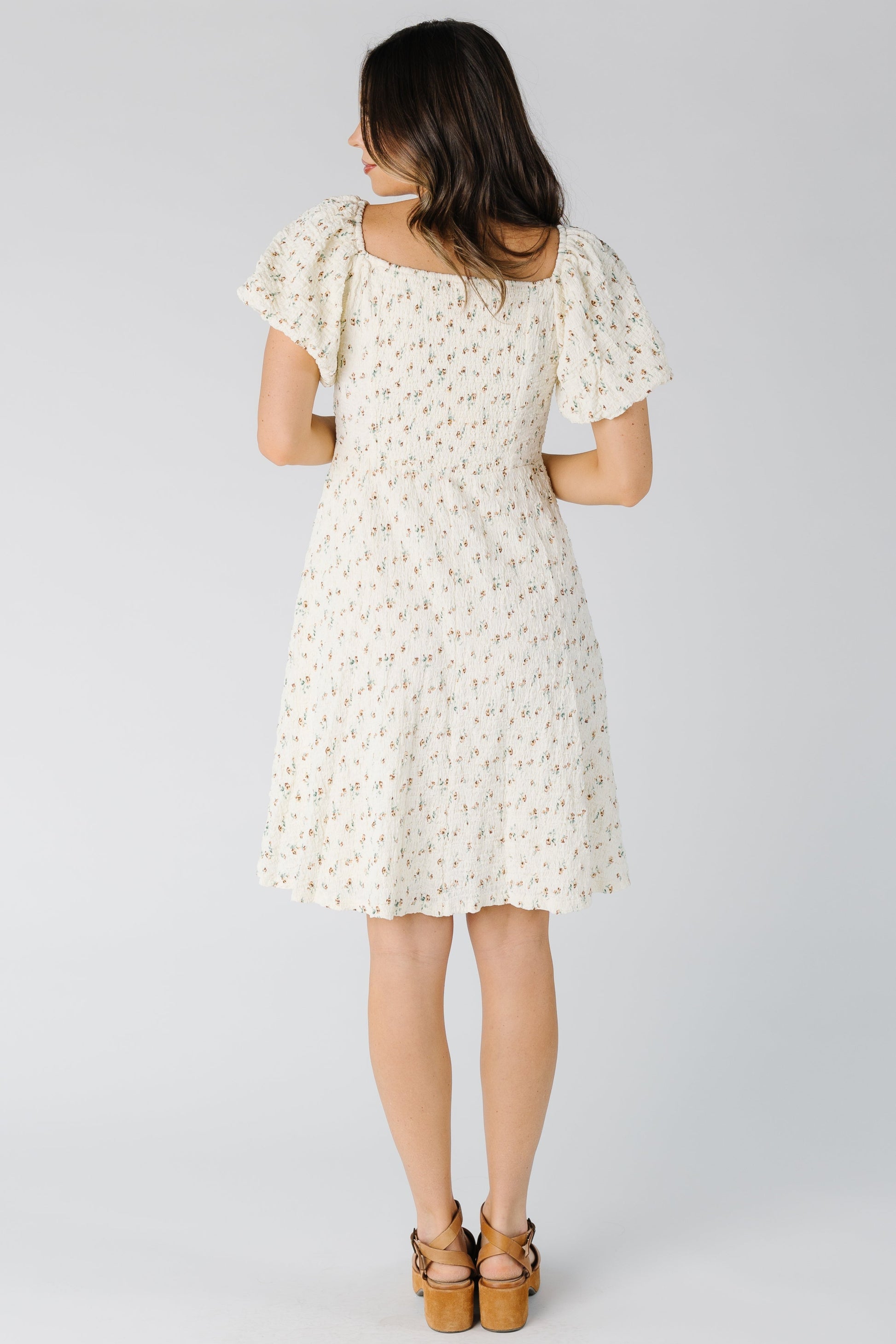 Back view of cream floral dress with short sleeves