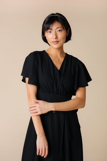 Close view of black modest wrap knee length dress