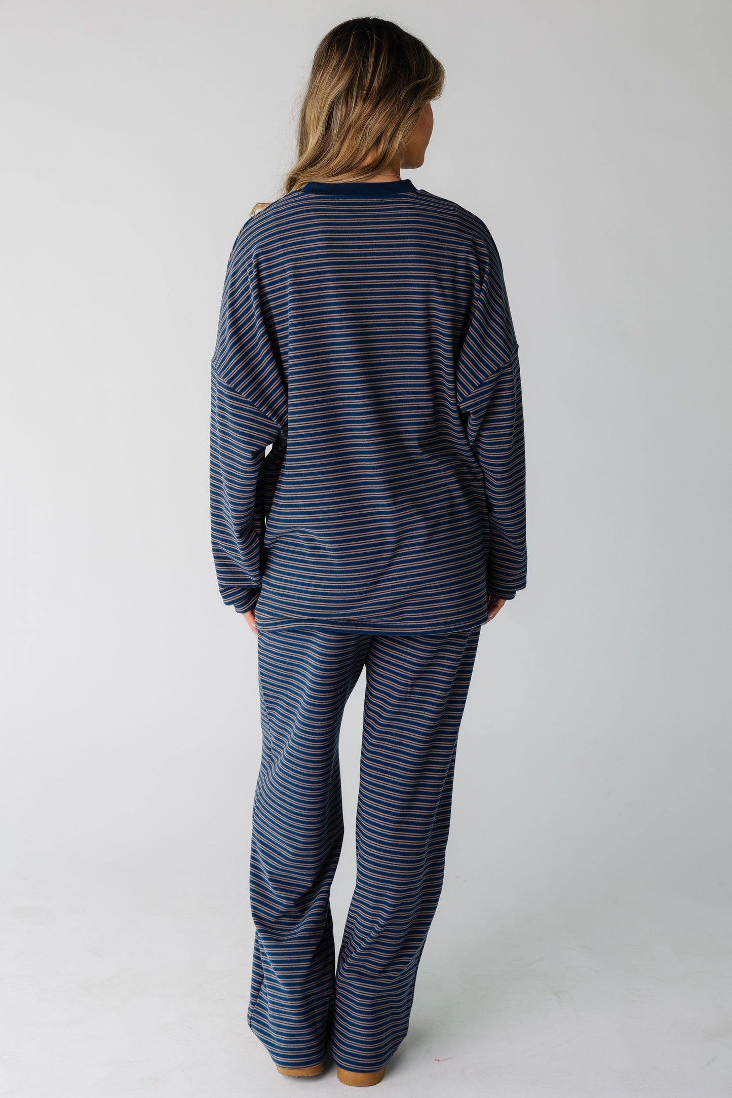 Back view of a woman wearing a loose, lounge set  with long sleeves.