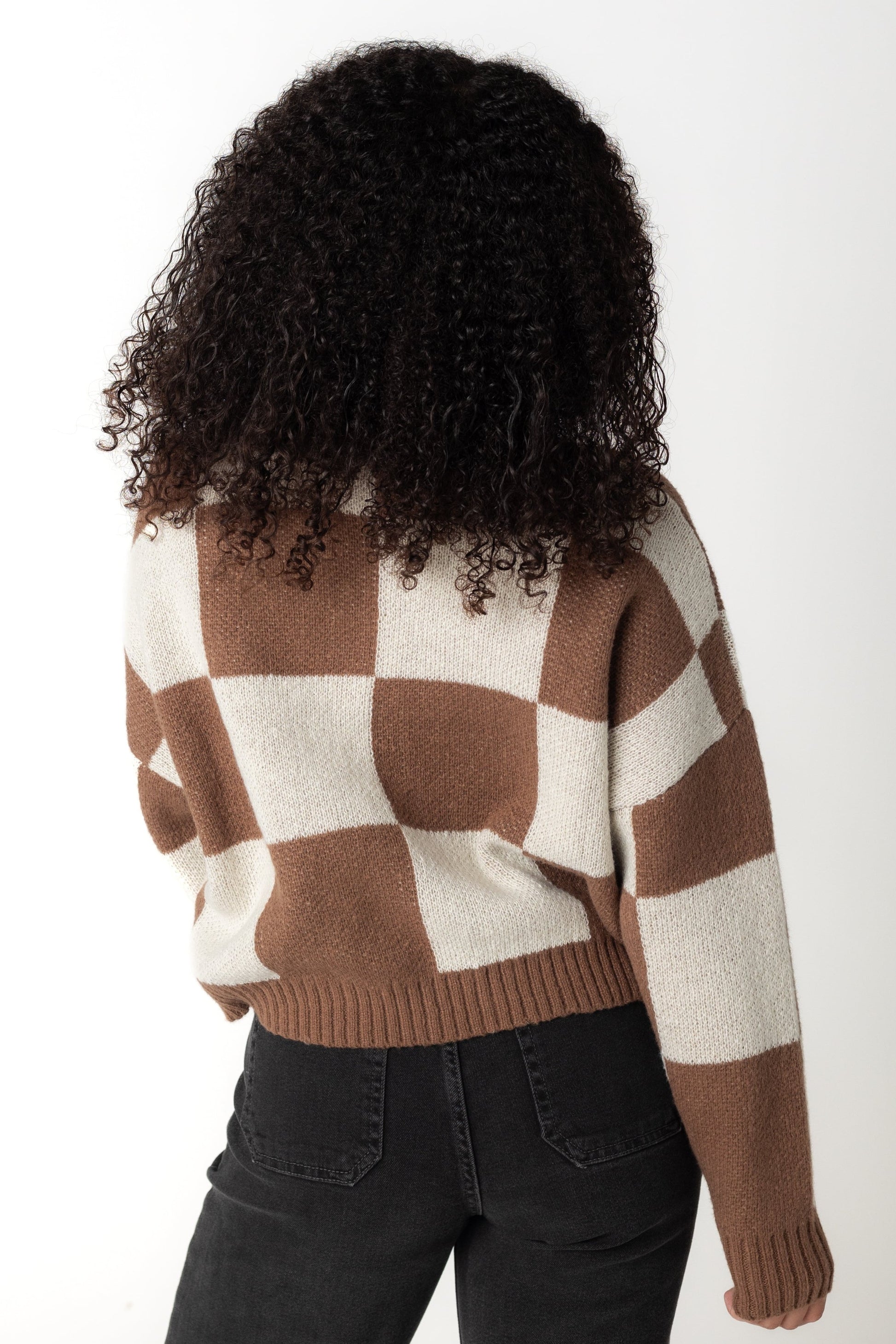 Back view of brown and cream checkered sweater with long sleeves