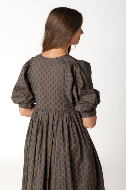 Back view of Brown and black print dress with loose gathered skirt and half length sleeves