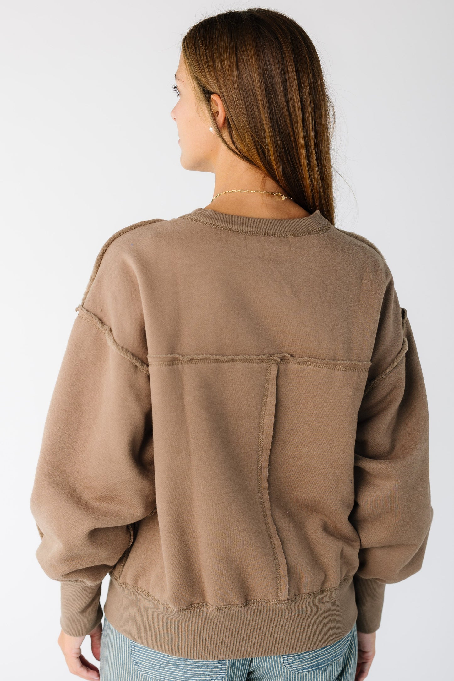 Woman wearing a loose fitting sweatshirt-sweater with long sleeves