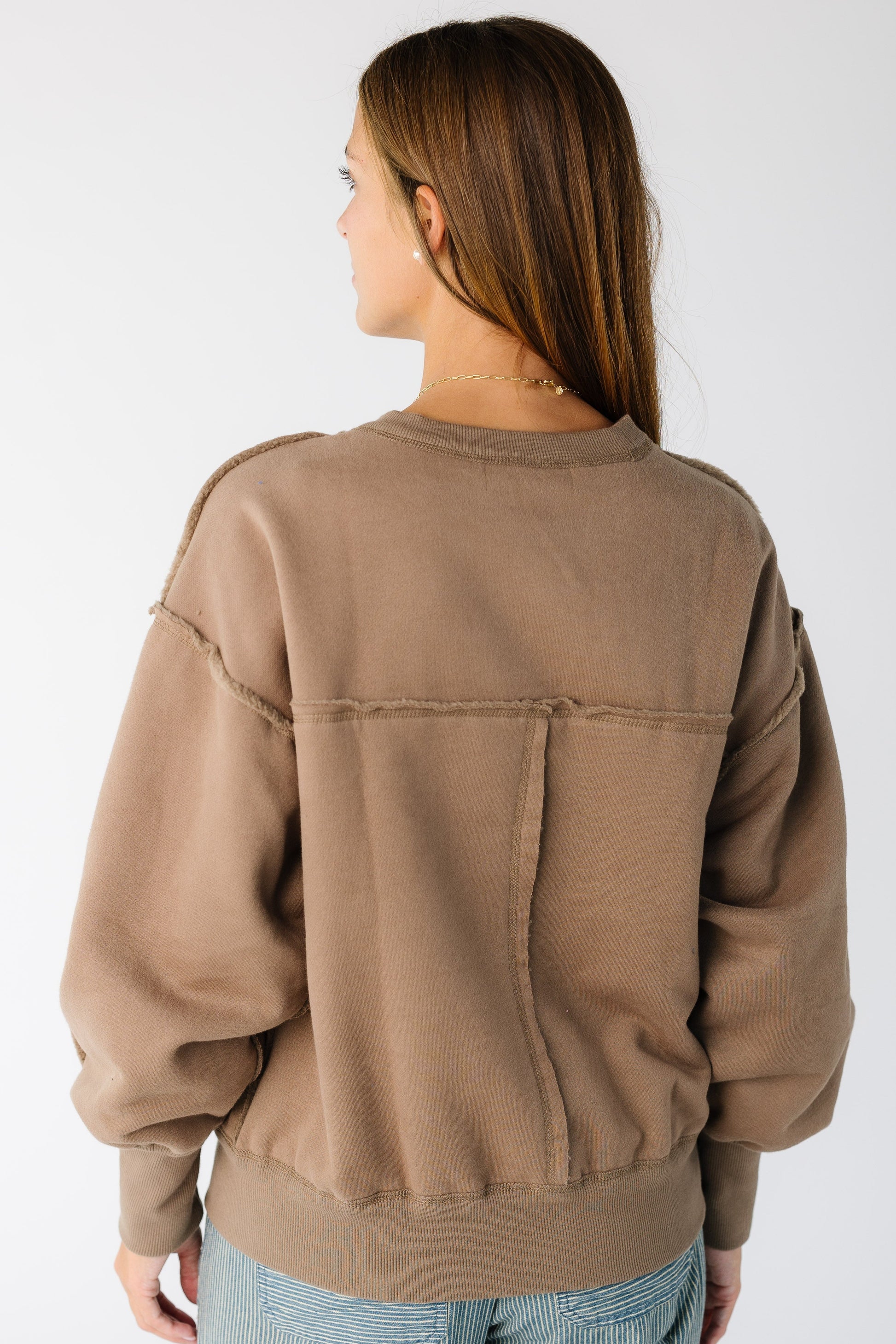 Woman wearing a loose fitting sweatshirt-sweater with long sleeves
