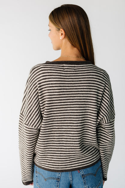 Back view of a woman wearing a brown stripe cardigan with long sleeves
