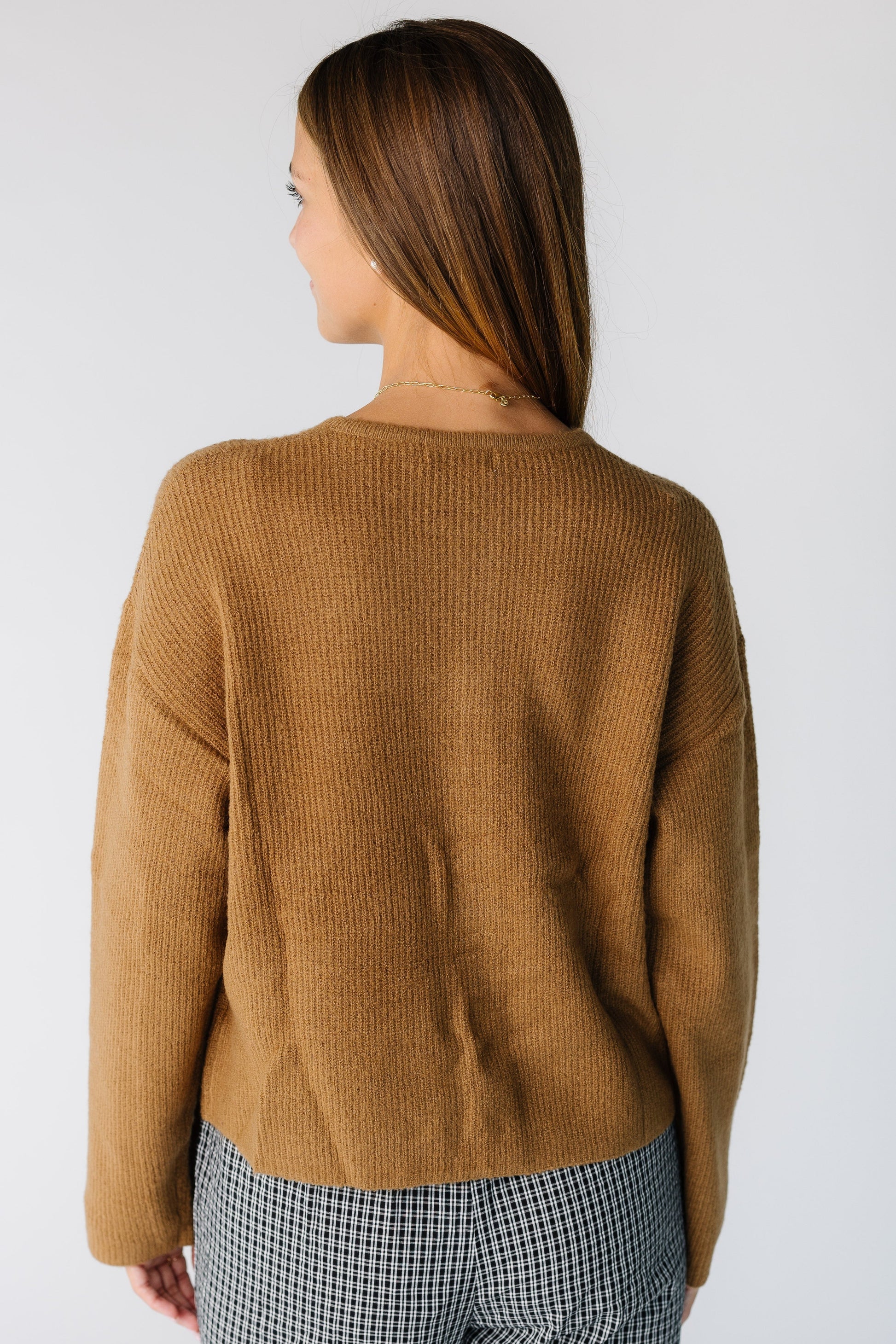 Back view of a woman wearing a brown long sleeve cardigan