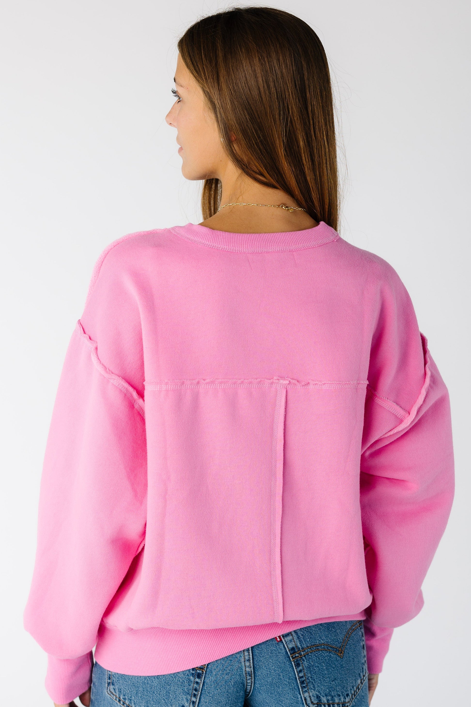 Woman wearing an exposed seam sweatshirt with long sleeves