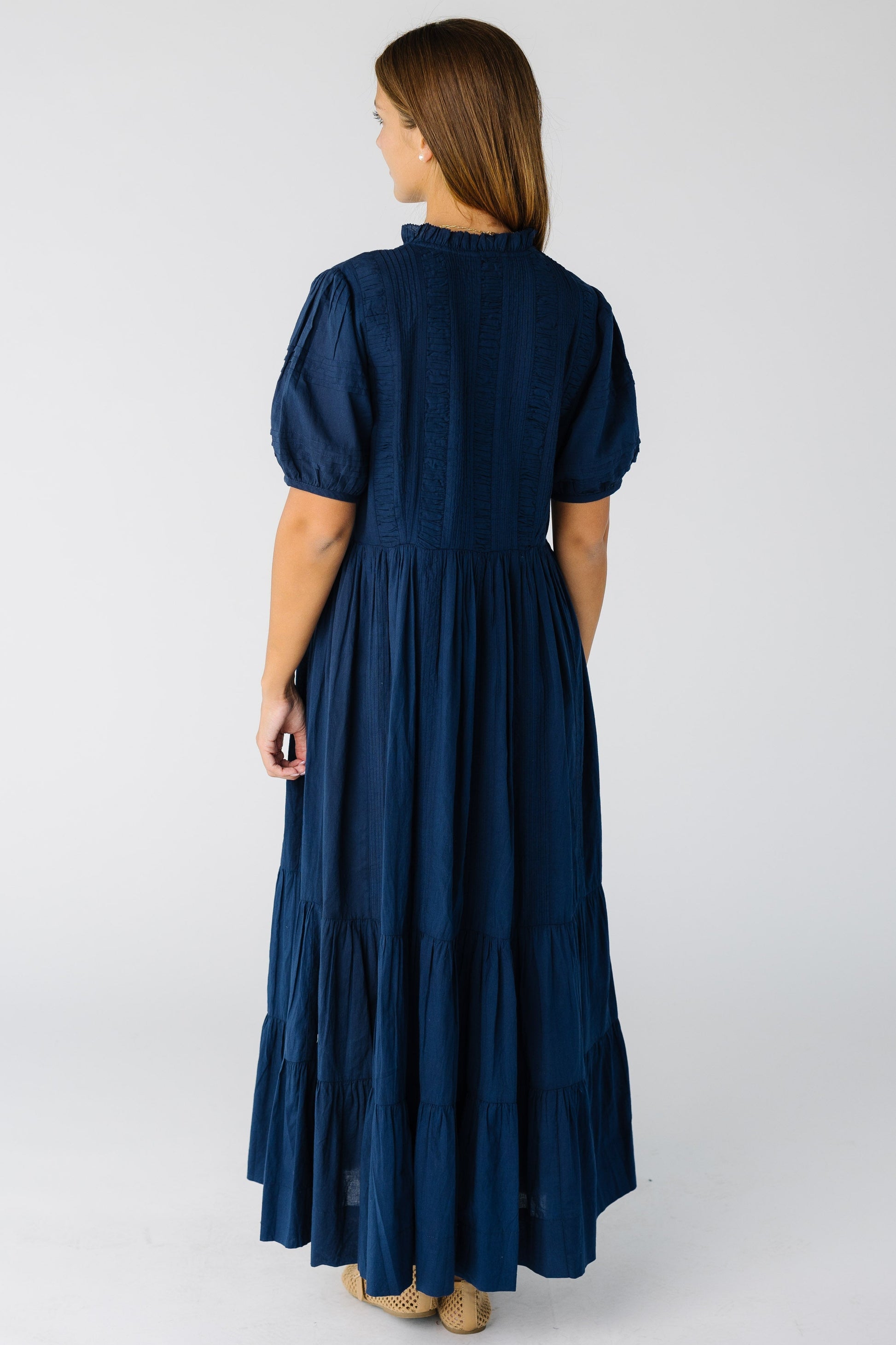 Back view of a woman wearing a navy maxi dress with short sleeves