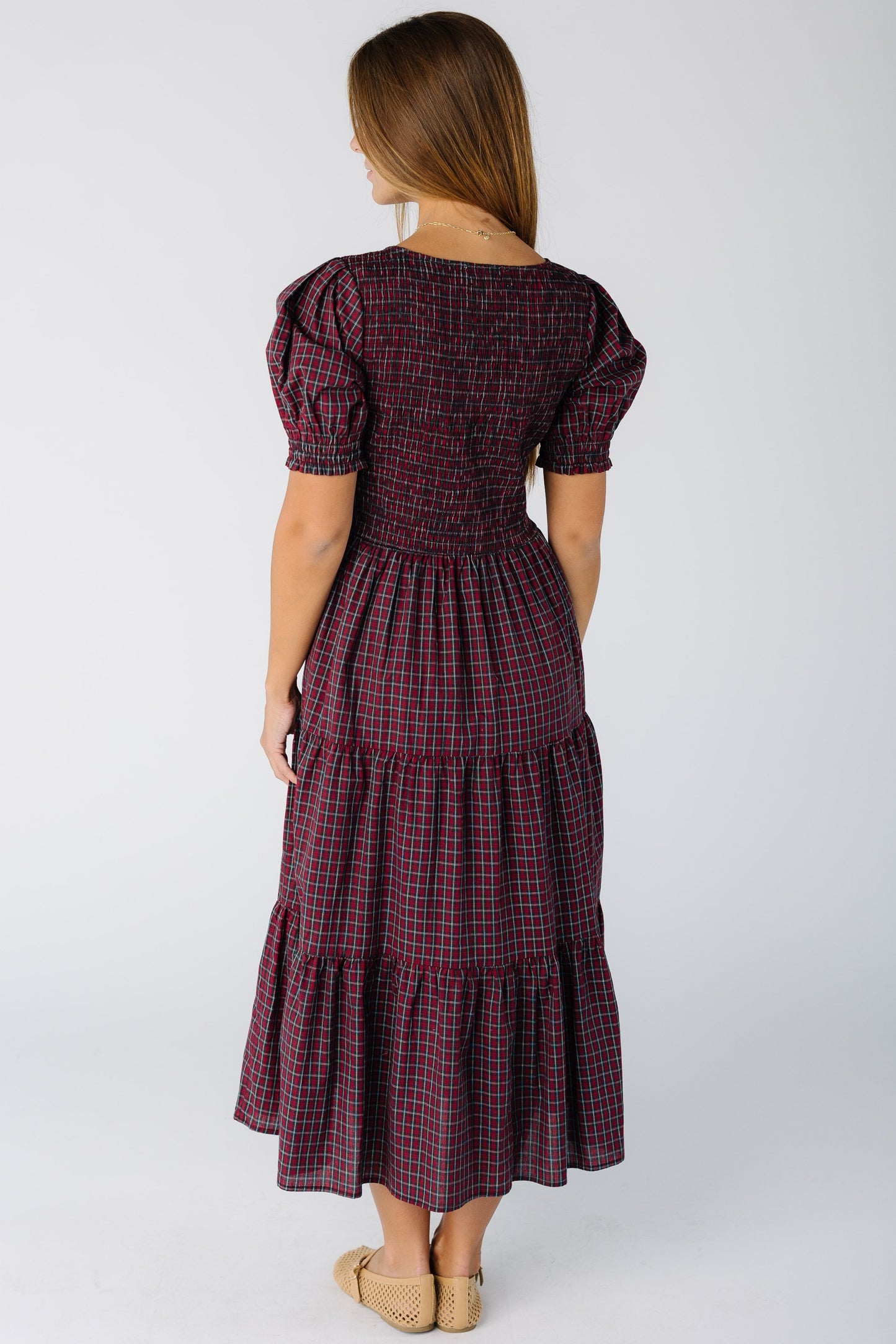 Back view of a woman wearing a modest red plaid midi dress with short sleeves