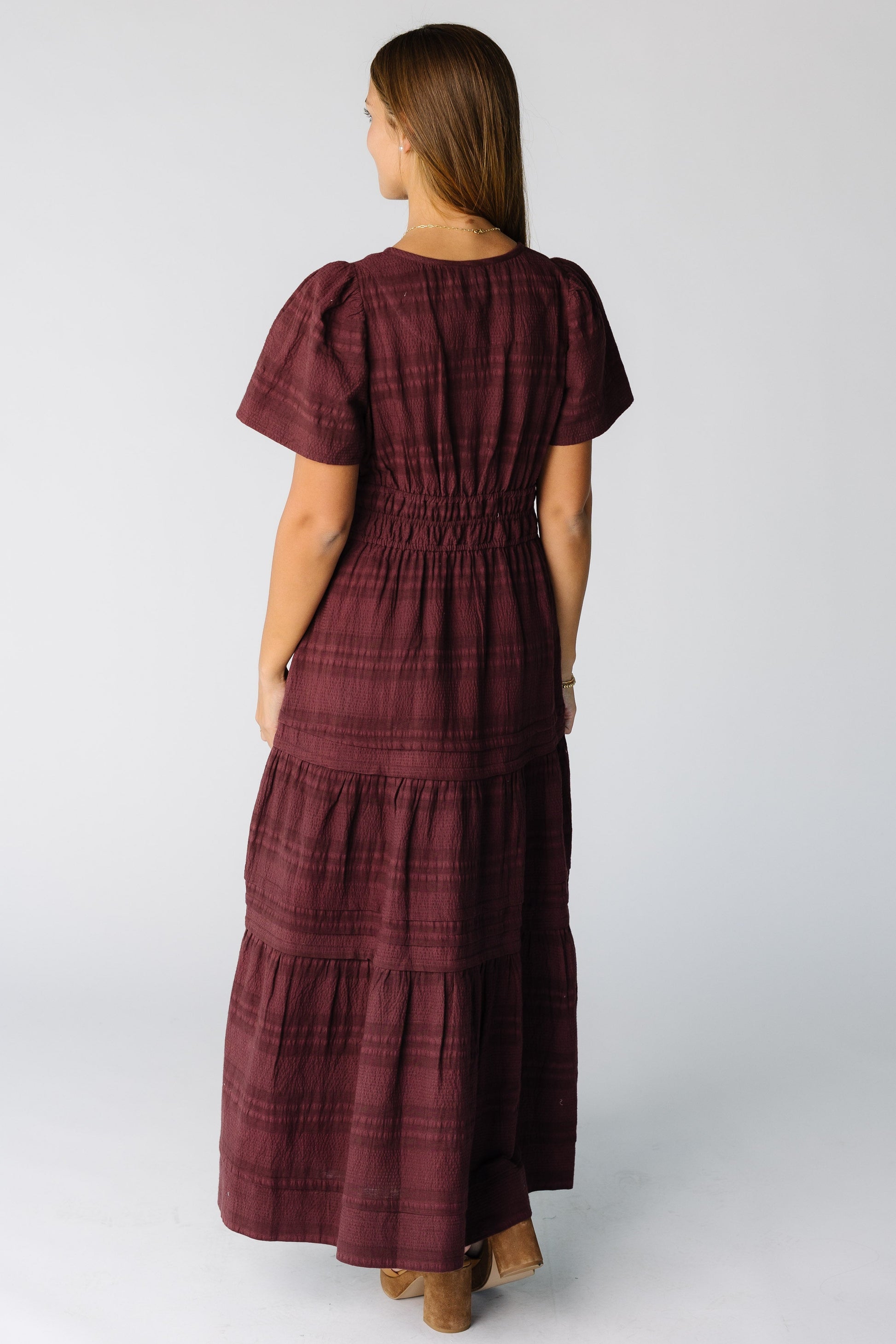 Back view of a woman wearing a burgundy maxi dress with short sleeves