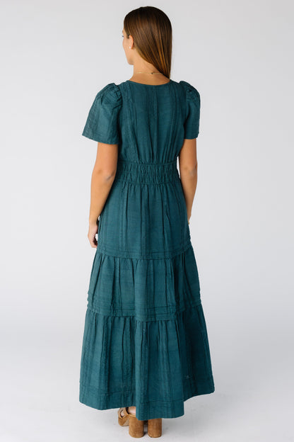 Back view of a woman wearing a teal maxi dress with short sleeves