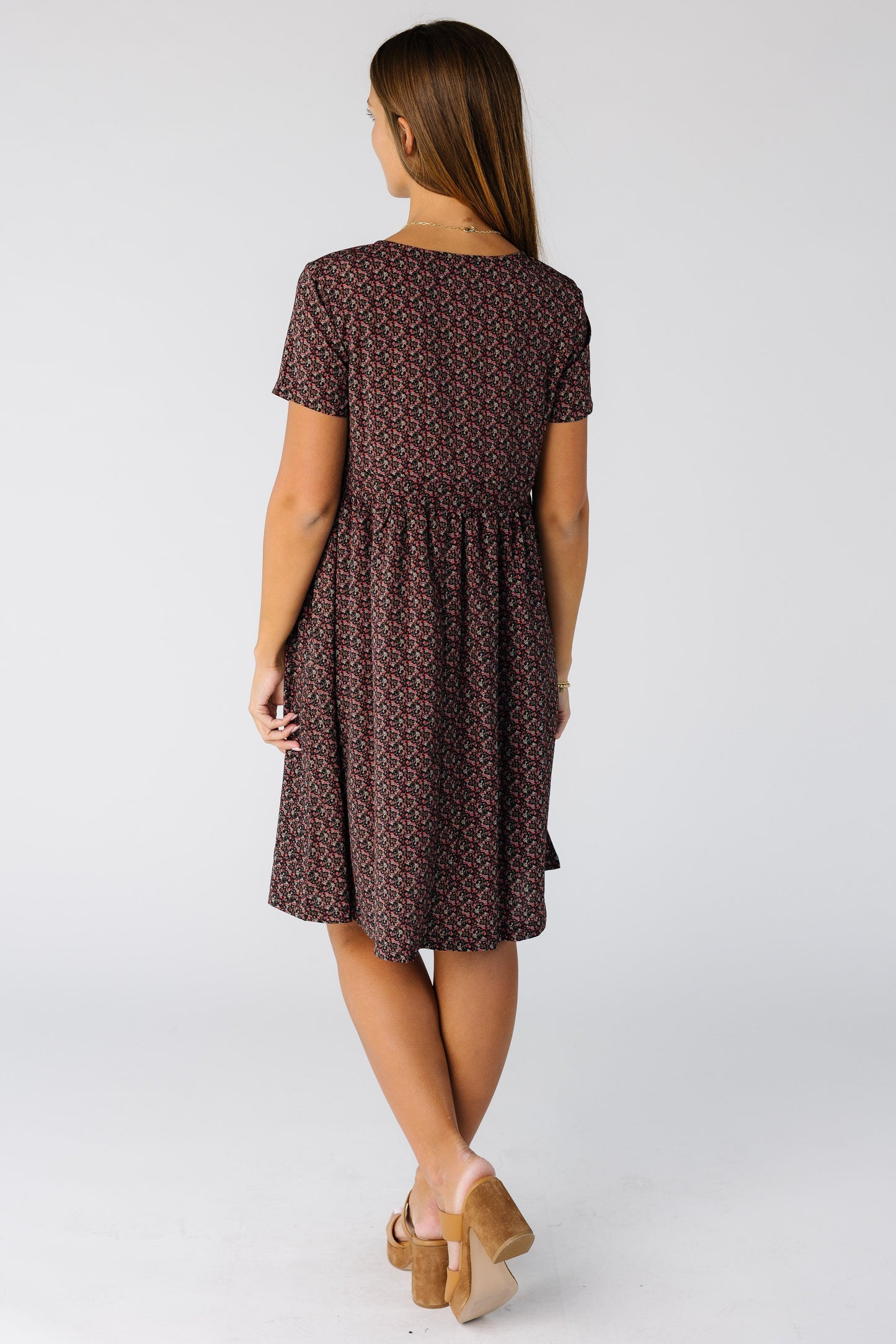 Back view of a woman wearing a knee length print dress with short sleeves