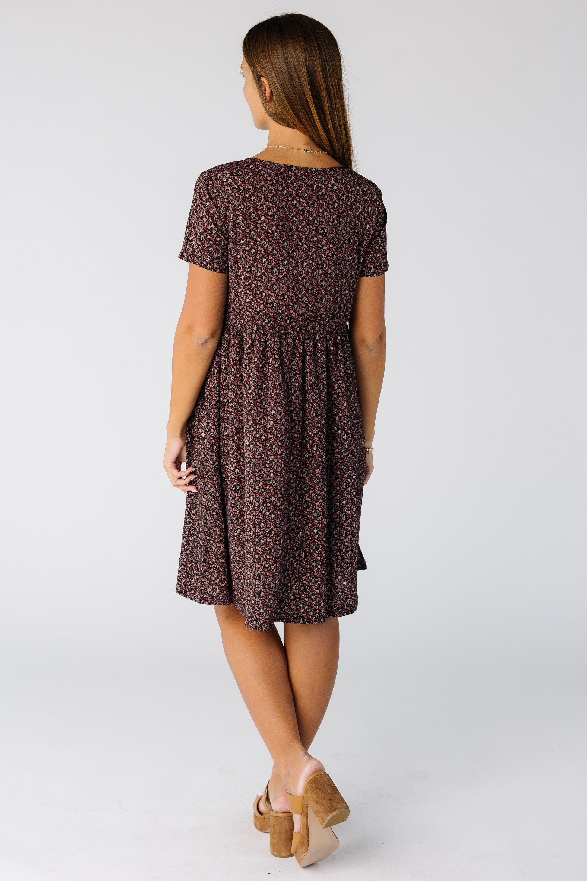 Back view of a woman wearing a knee length print dress with short sleeves