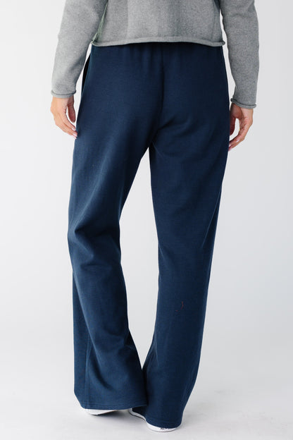 Back view of a wearing a pair of navy wide cut lounge pants