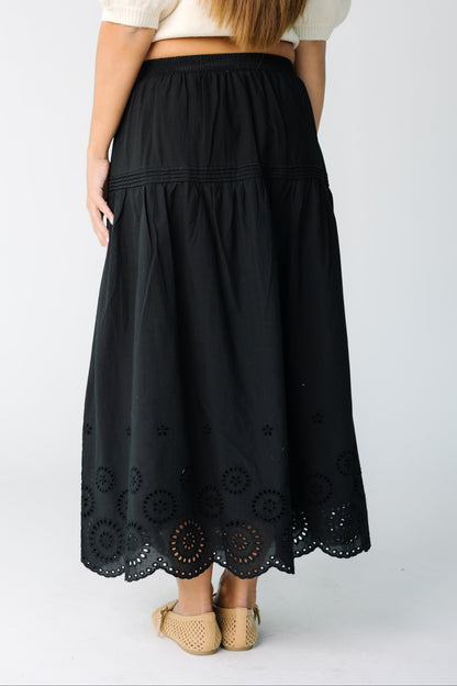 Back view of a woman wearing a black eyelet midi skirt